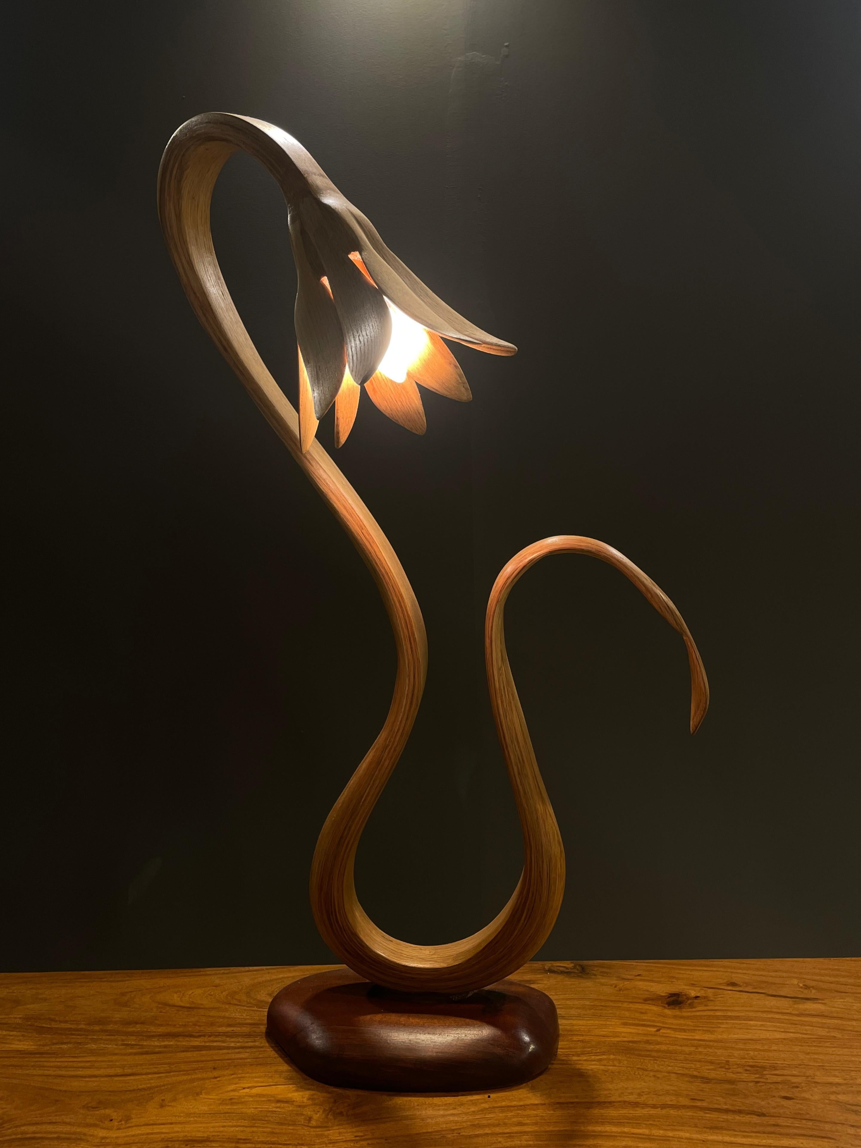 Die Tischleuchte hat ein freies Design; das Holz biegt und krümmt sich mit schönen Flüssen, um das Design zu schaffen. Die handgefertigten Details wie die Rundungen und die unterschiedliche Dicke des Holzes verleihen dem Stück einen organischen