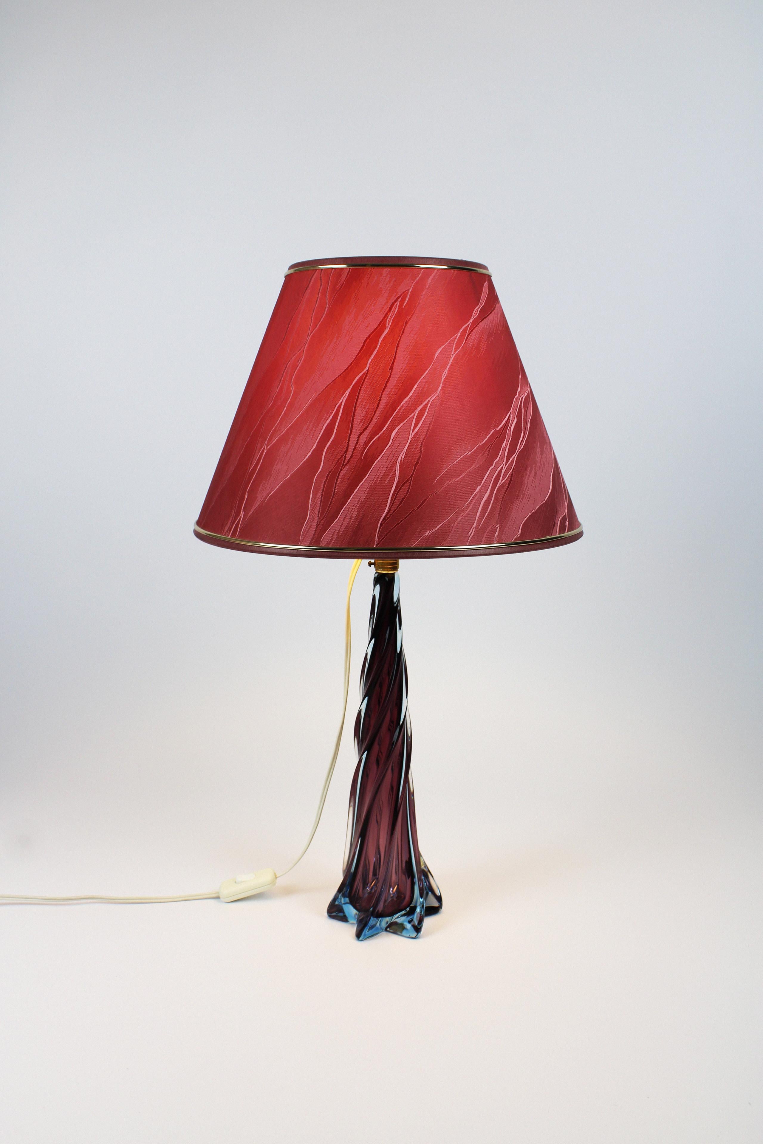 Meet this organic forming table lamp that consists of the rare Artistica Murano CCC & hand-blown Sommerso collection. The Murano glass that is crafted with a warm hue consisting of grape and blue comes and forms the stand in a twisted design. The
