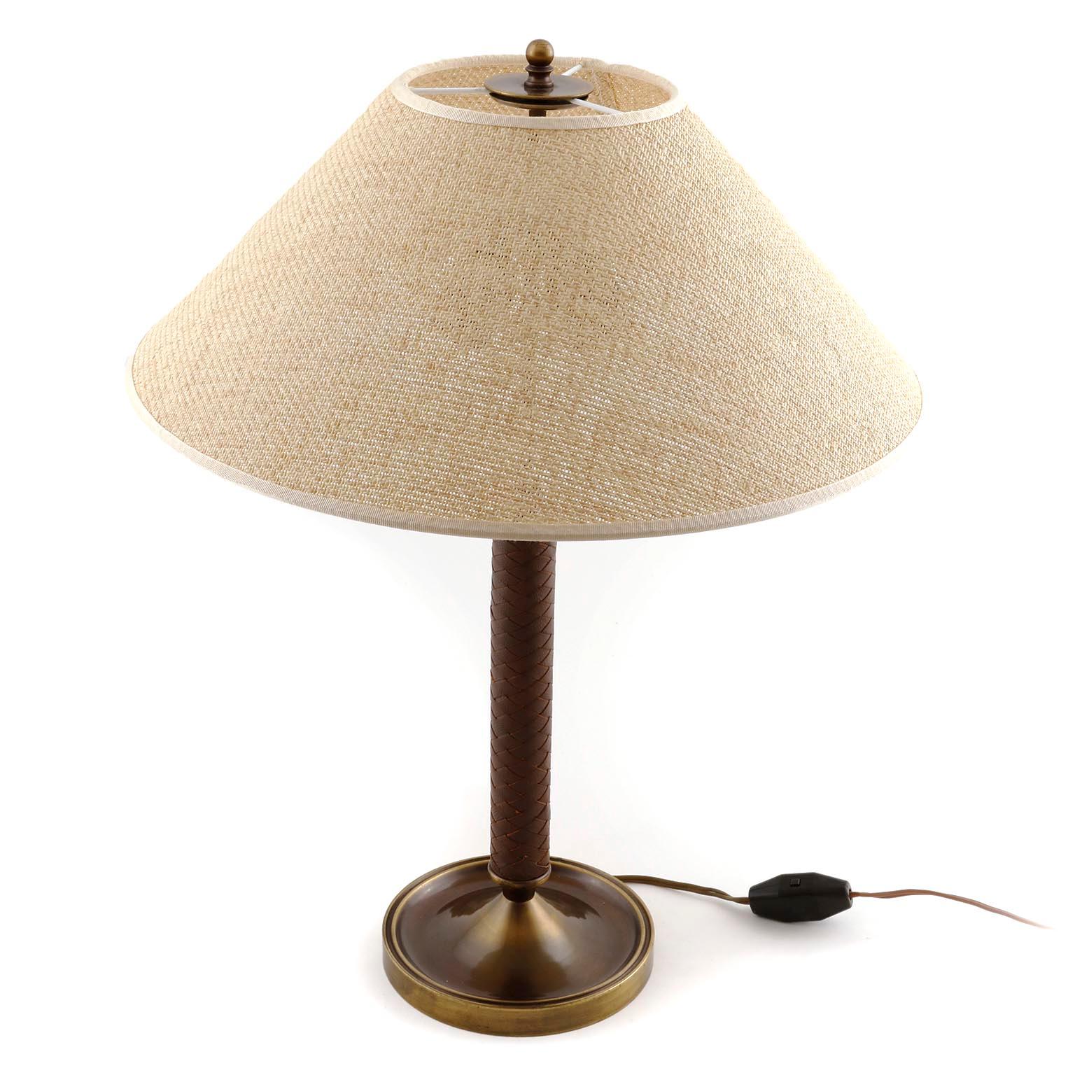 A gorgeous and large table or desk lamp manufactured in midcentury in Austria in 1950s.
The Stand is made of patinated brass (similar to bronze) and a plaited brown leather handle.
The cone shaped lamp shade has been renewed and it is made of thin