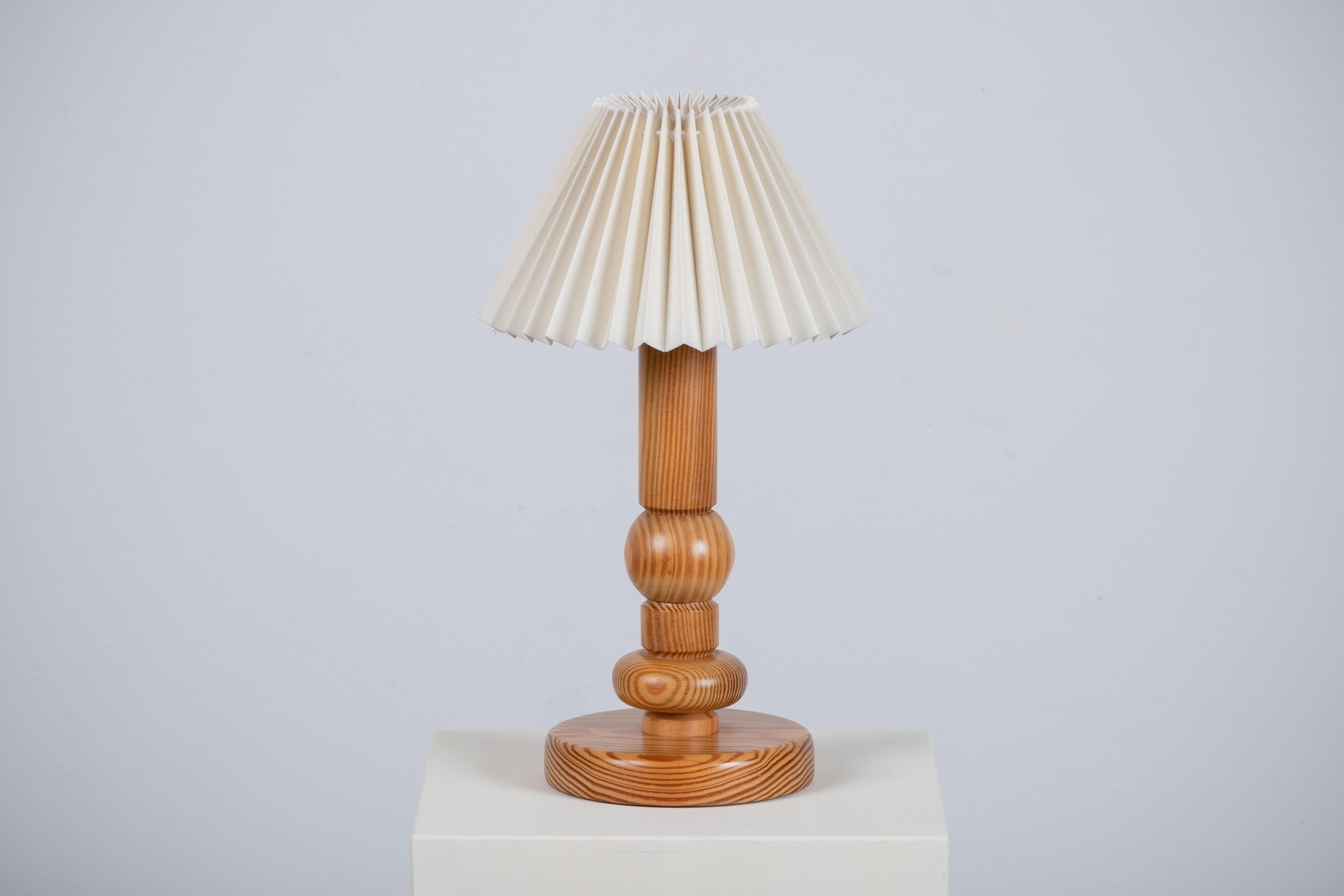 A Swedish craft table lamp. In solid pine, Sweden, 1970. 

Pretty lamp with fir wood base and pleated lampshade. It is in good general condition and works perfectly. The diffused light is very pleasant and the lamp offers a warm