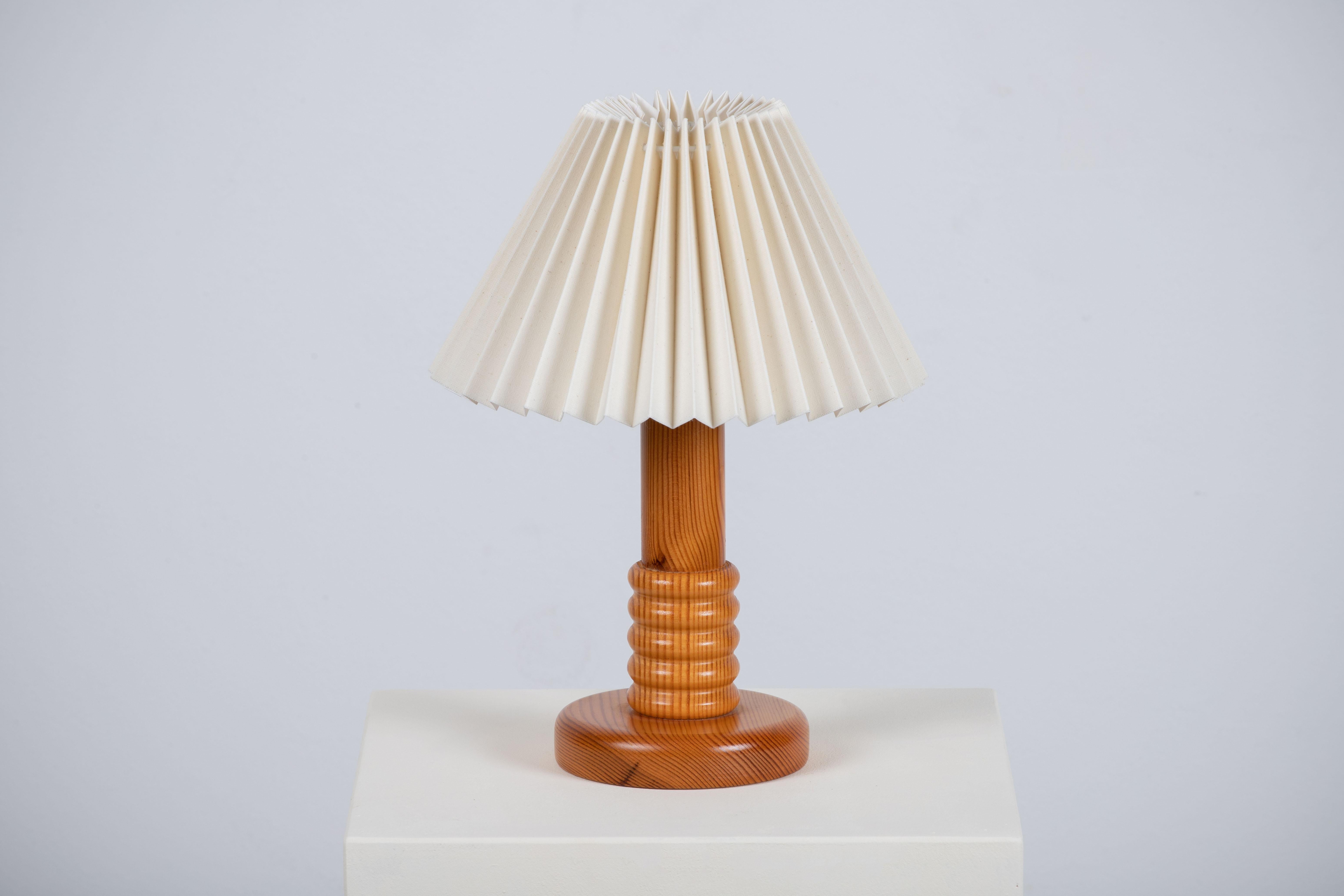 A Swedish craft table lamp. In solid pine, Sweden, 1970. 

Pretty lamp with fir wood base and pleated lampshade. It is in good general condition and works perfectly. The diffused light is very pleasant and the lamp offers a warm