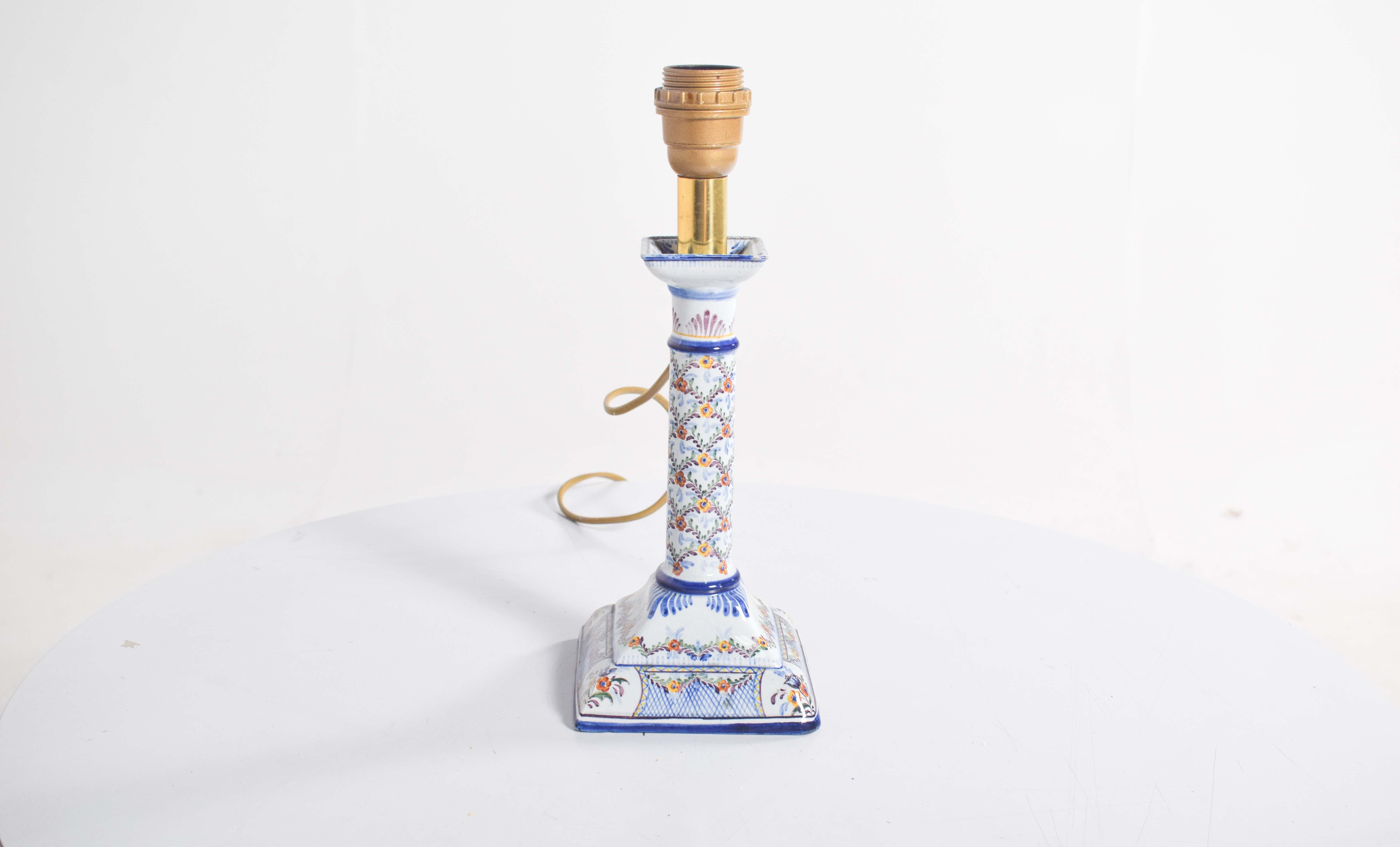 Ce luminaire électrifié unique, façonné sous la forme d'un chandelier traditionnel, incarne le charme des céramiques portugaises de Candal. Sa base carrée constitue un socle stable, orné d'un décor polychrome complexe dominé par des tons bleus