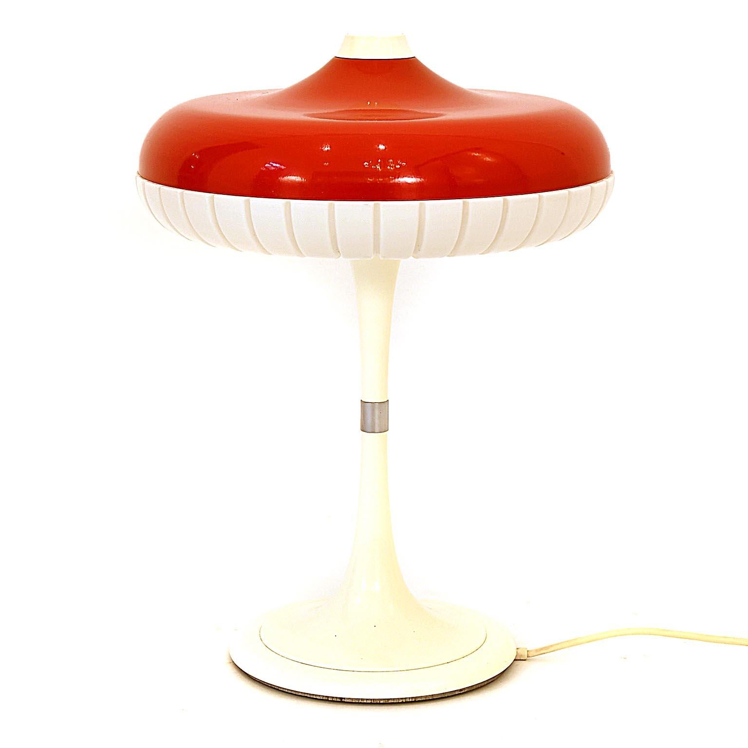 Table lamp designed by Siemens, circa 1960s. Red plastic shade with a white cast iron base. Located on the top is the on/off switch.
Fine original condition. Flourescent lamp 32 watt. The lamp is branded with paper label inside.