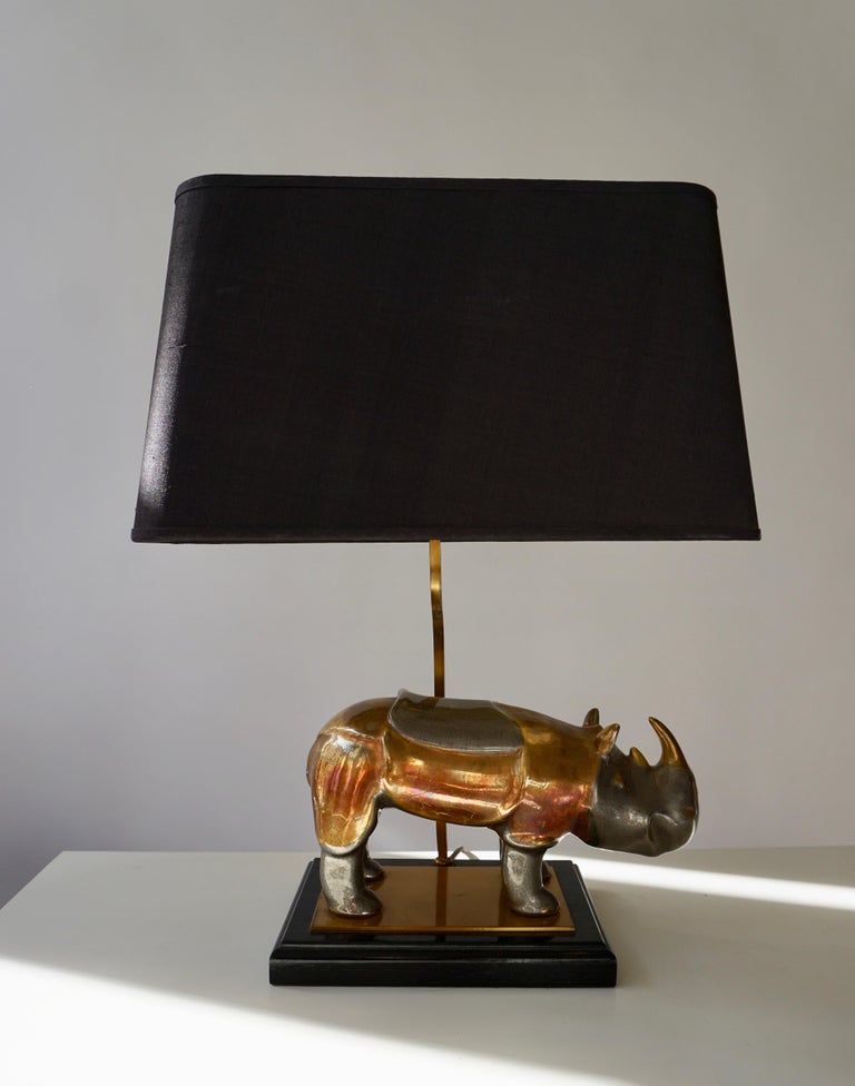 Brass rhinoceros lamp on a wooden base with original shade.
Measure: Height 51 cm.
Width shade 40 cm.
Depth shade 22 cm.
Width rhino29 cm, height 18 cm.
0ne E27 bulb.