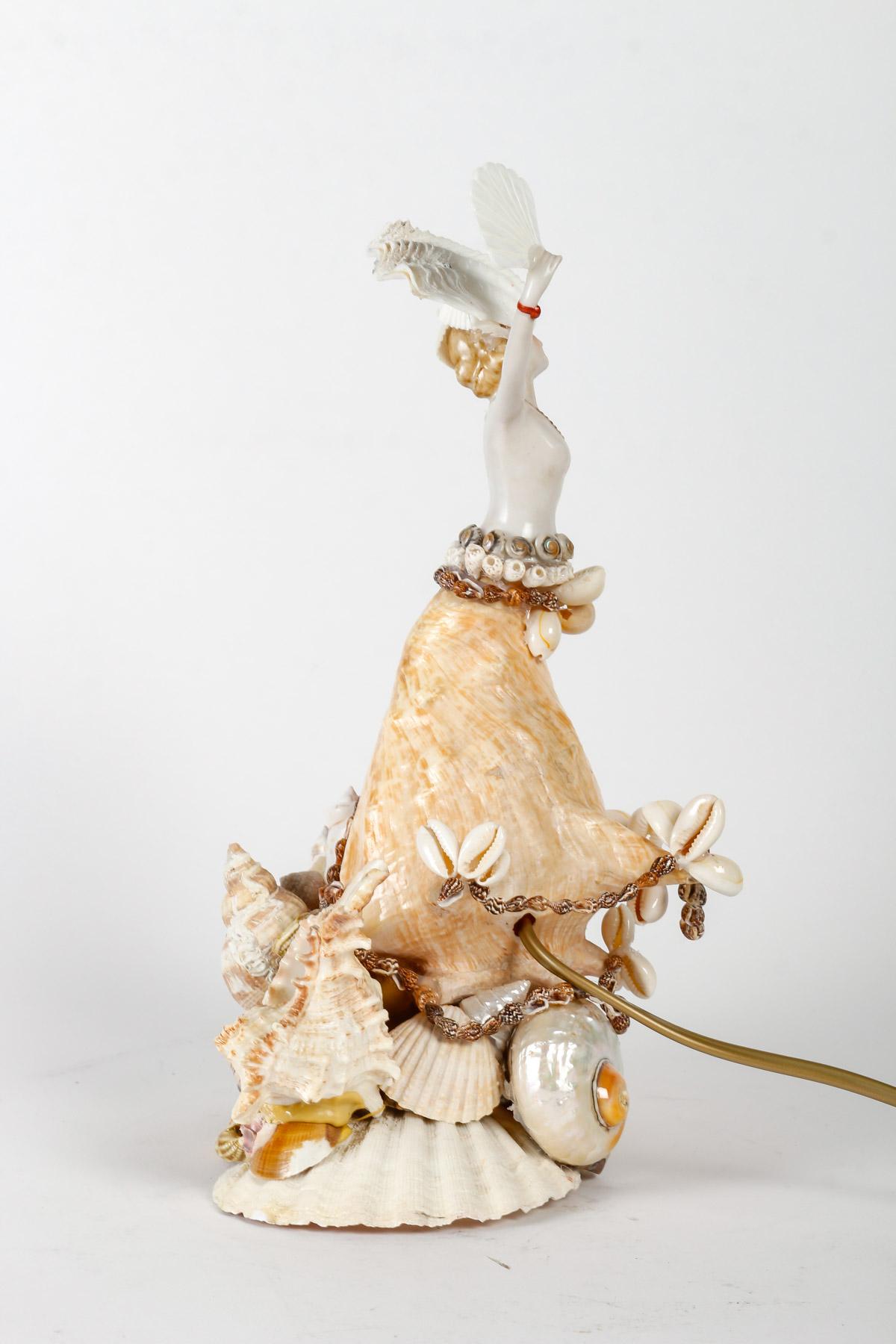 Table lamp, shell sculpture, porcelain figure forming a night-light in the central shell, 20th century.
h: 30cm, w: 21cm, d: 17cm