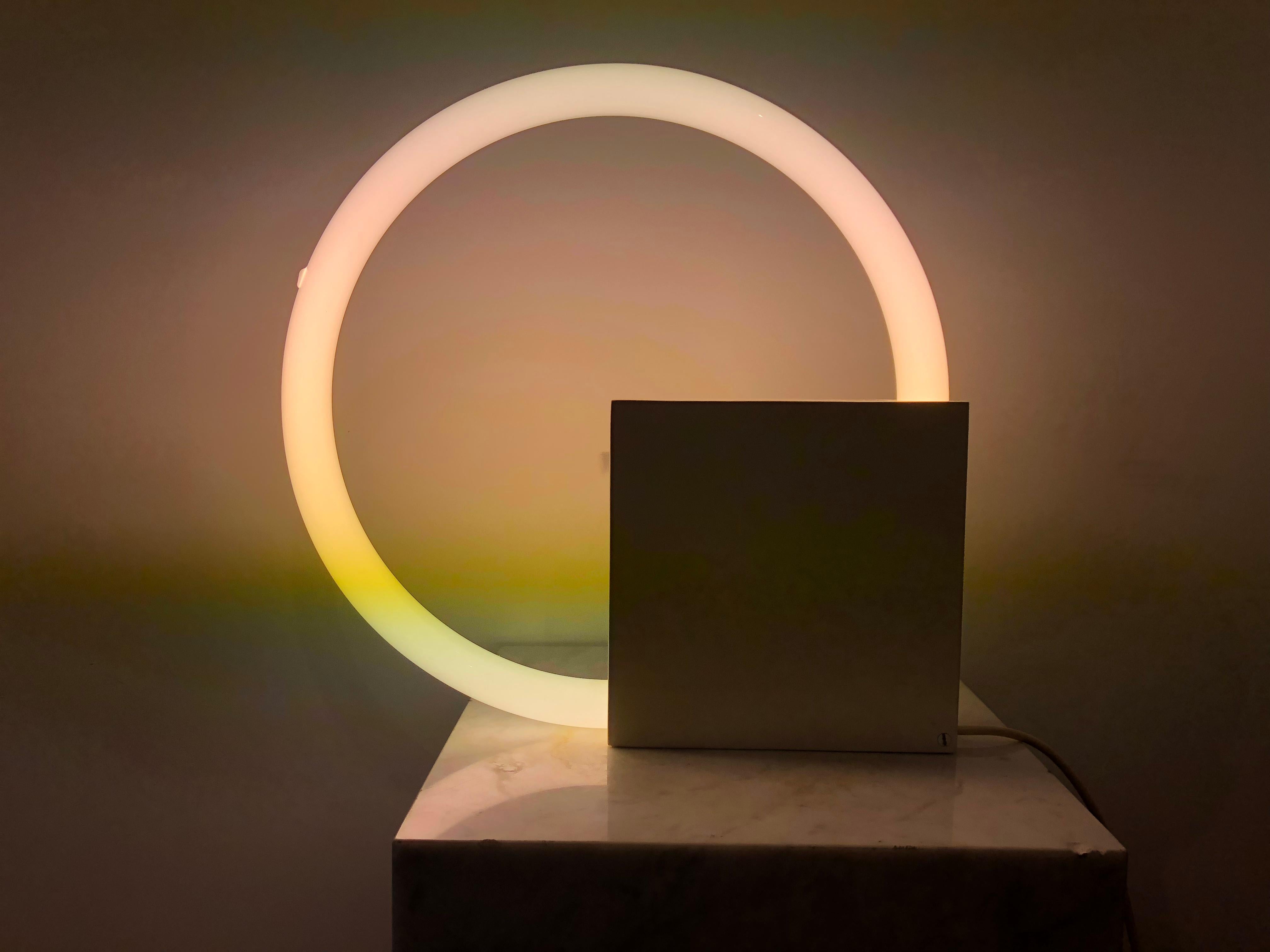 Table lamp (or also wall lamp) made of painted steel and round neon.
Inspired by the minimalism aesthetics movement, the Dutch designer Aldo van den Nieuwelaar combined the simplicity and purity of forms in a lightning sculpture.