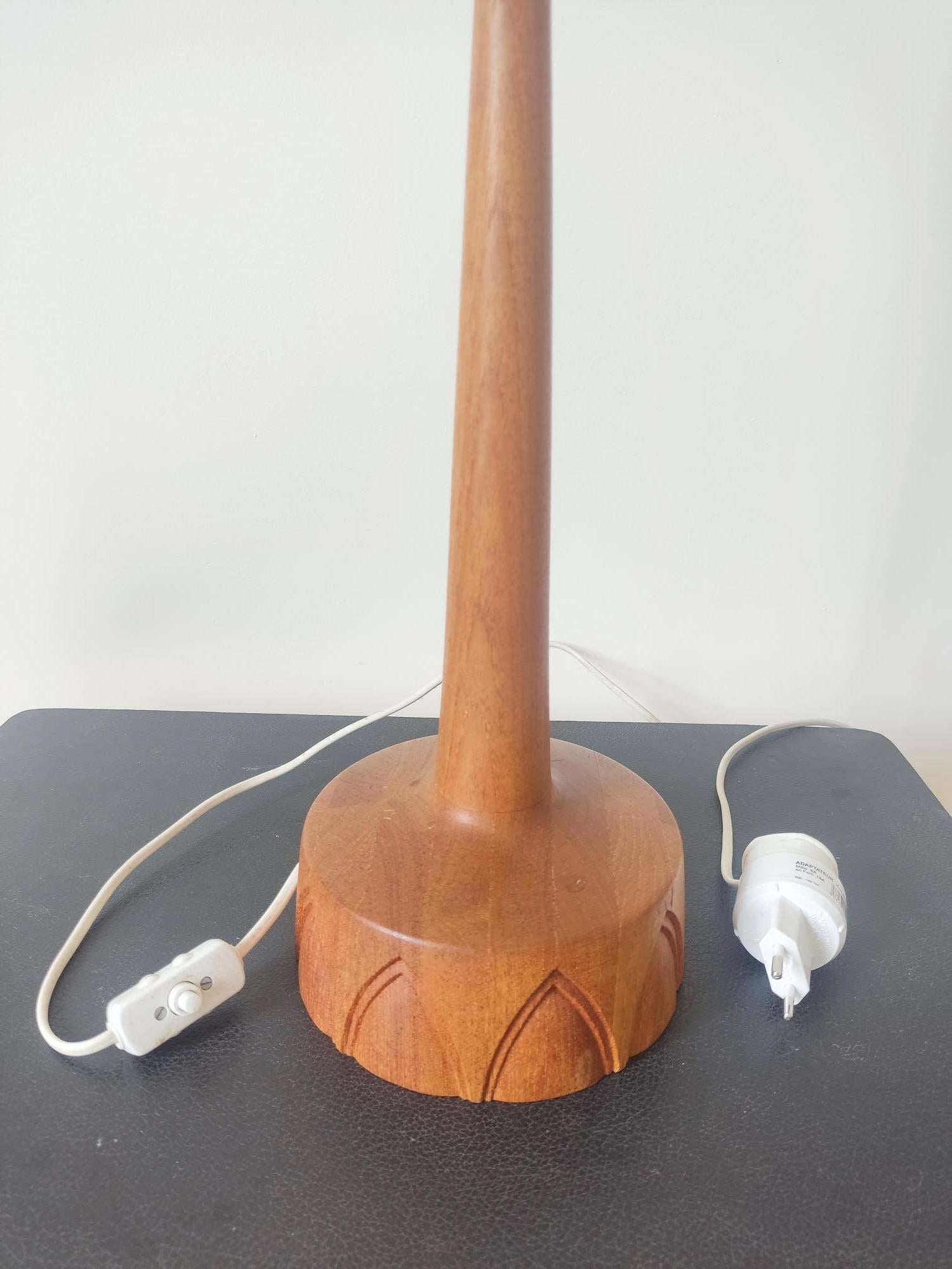 L'élégante lampe de table a été produite par AB Stilarmatur Tranås en Suède dans les années 1960. Fabriquées en bois de teck, les bases circulaires présentent un intéressant motif arqué sculpté à la main. L'interrupteur est un bouton poussoir situé