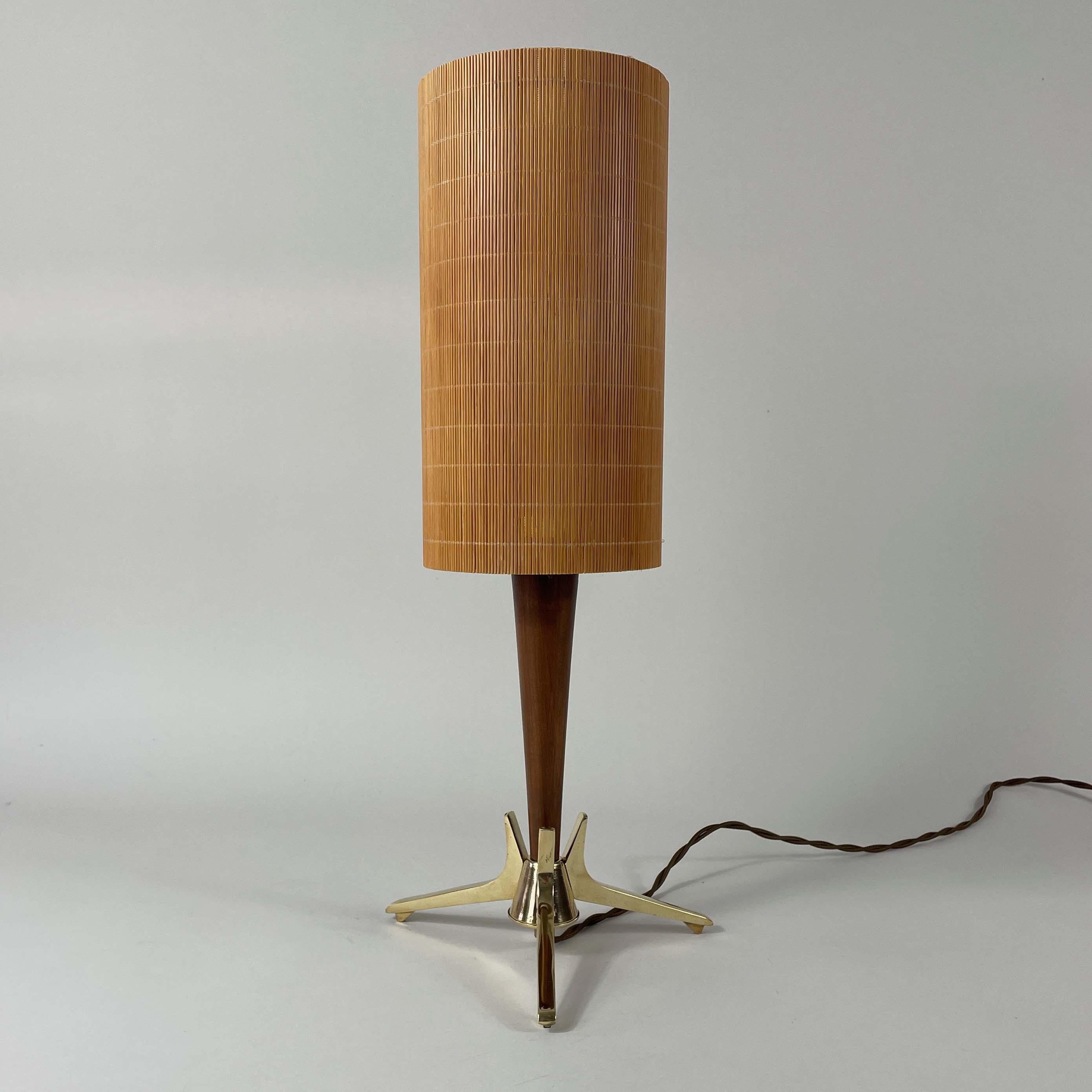 Cette lampe de table de designer suédois a été conçue et fabriquée dans les années 1950. Elle se compose d'une base tripode en laiton, d'une tige en teck et d'un abat-jour en rotin.

Le design général est élégant, fonctionnel et caractéristique de