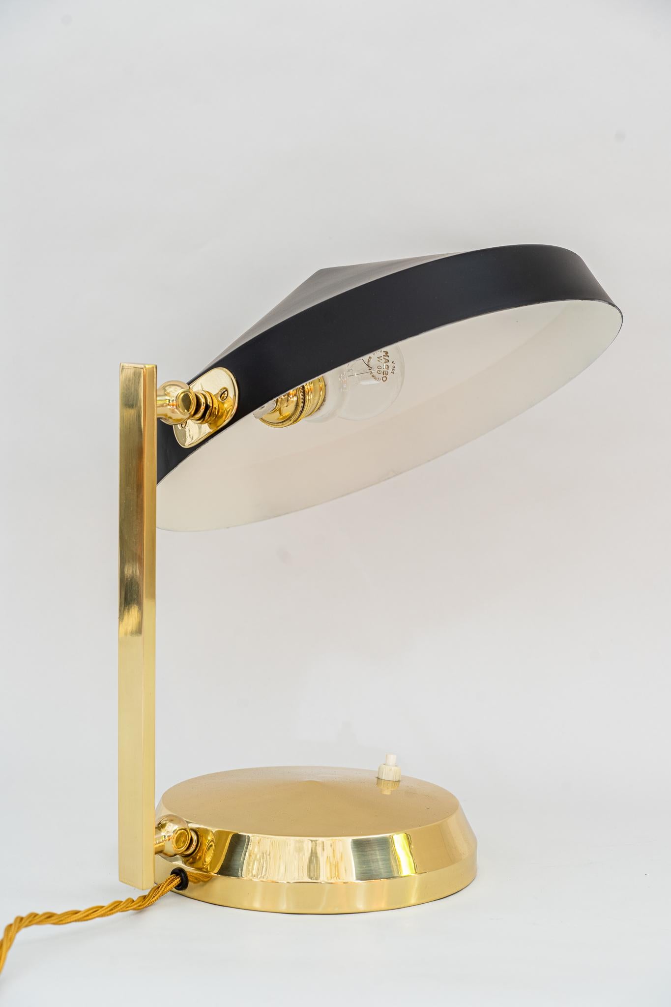 Lampe de table viennoise vers 1960
Laiton poli et émaillé au four
L'abat-jour est en aluminium (laqué noir).