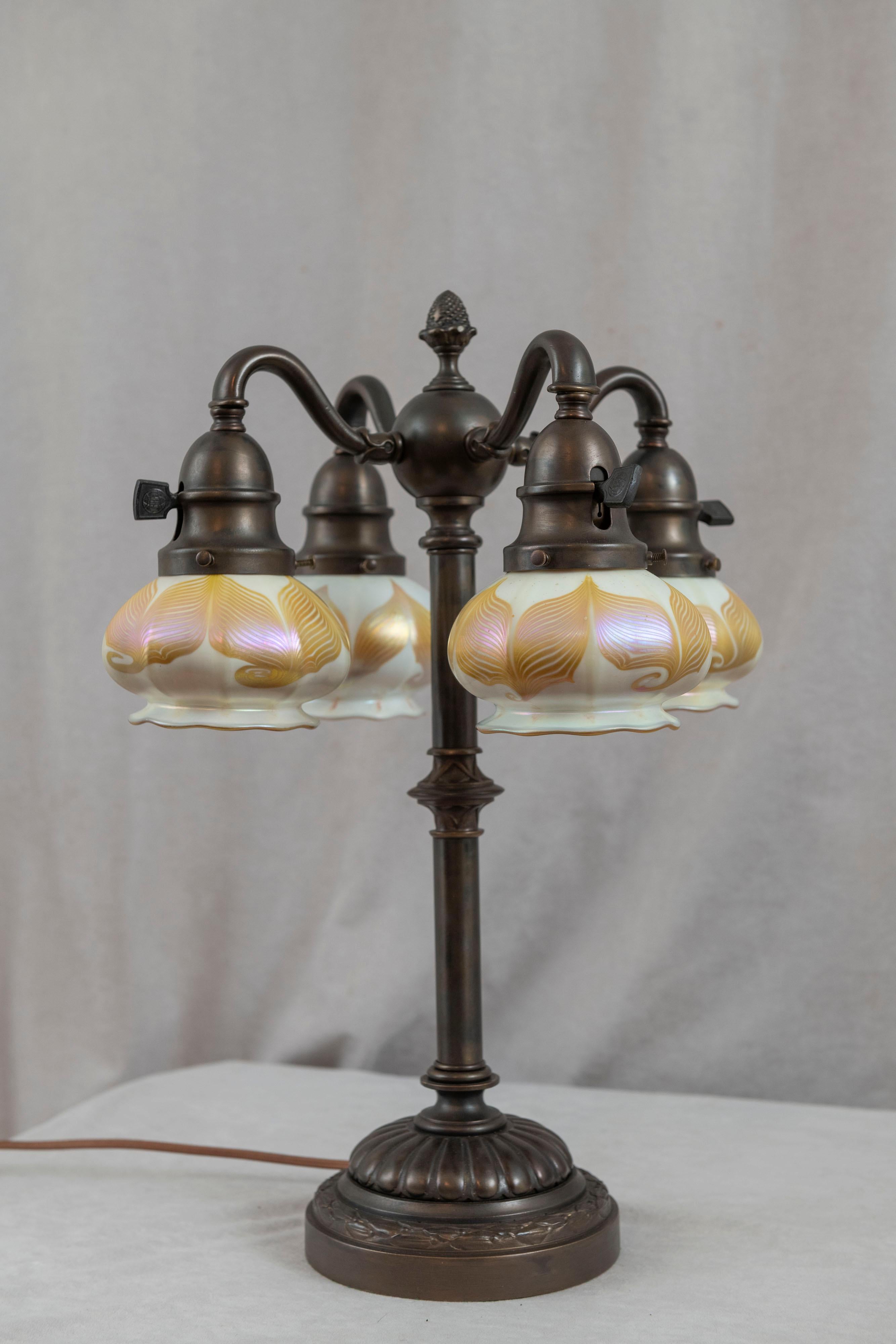 This is quite an extraordinary lamp The base is unsigned, possibly Bradley & Hubbard. These shades are the smallest art glass shades we have ever seen. They are hand blown and are all signed 