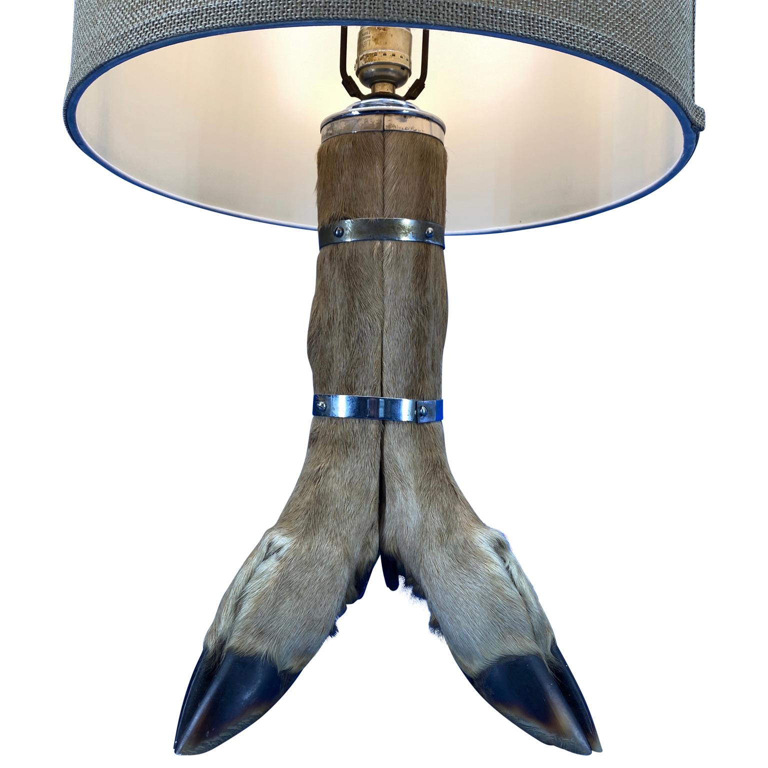 Mid-Century table lamp with 4-tier deer hoof with nickel bands and brass fitted antler finial.

Shade is not included.