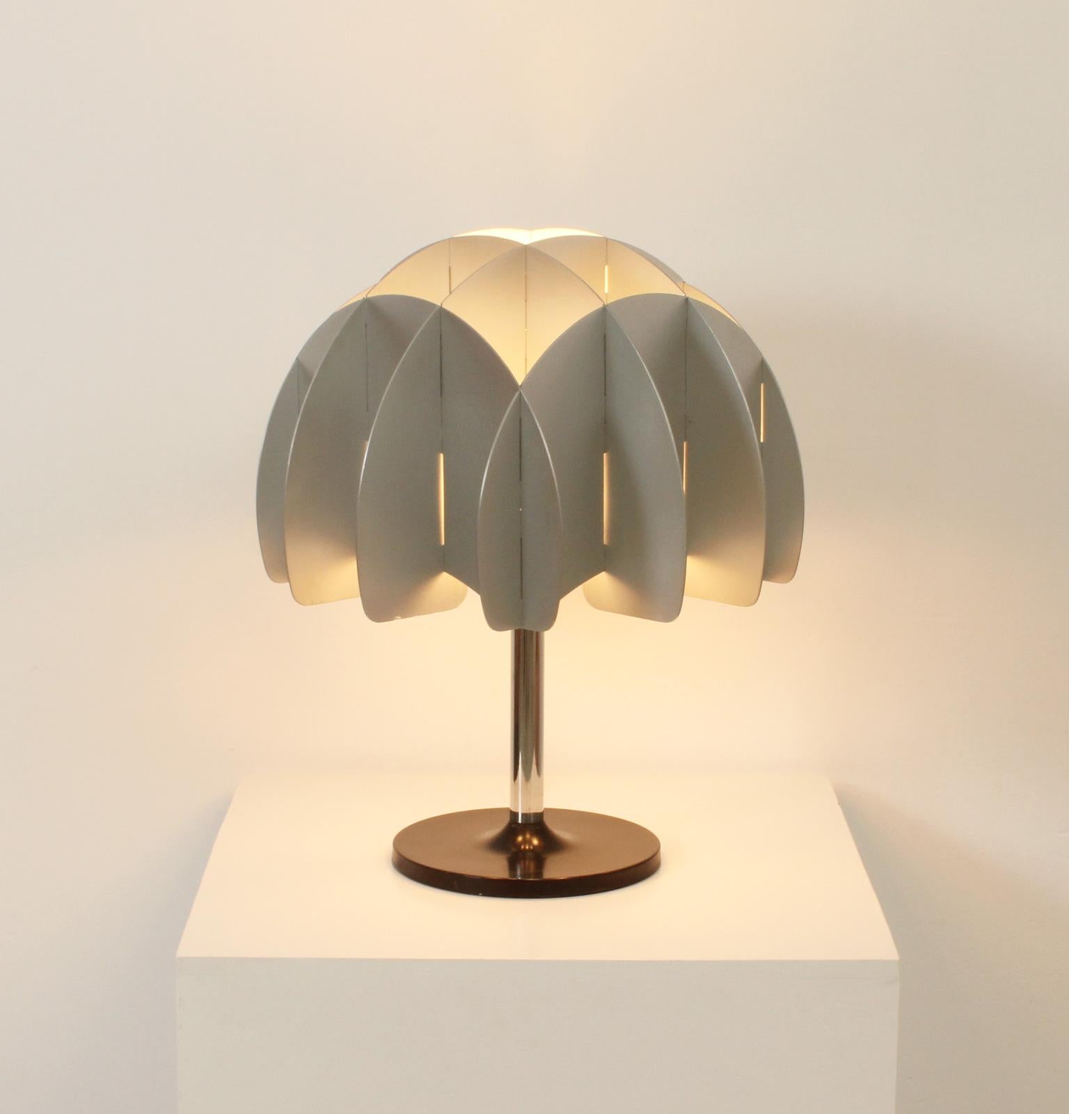 Lampe de table des années 1970 produite par Reggiani, Italie. Excellent travail réalisé avec des plaques d'aluminium en guise de dôme avec une base en métal chromé et laqué. 