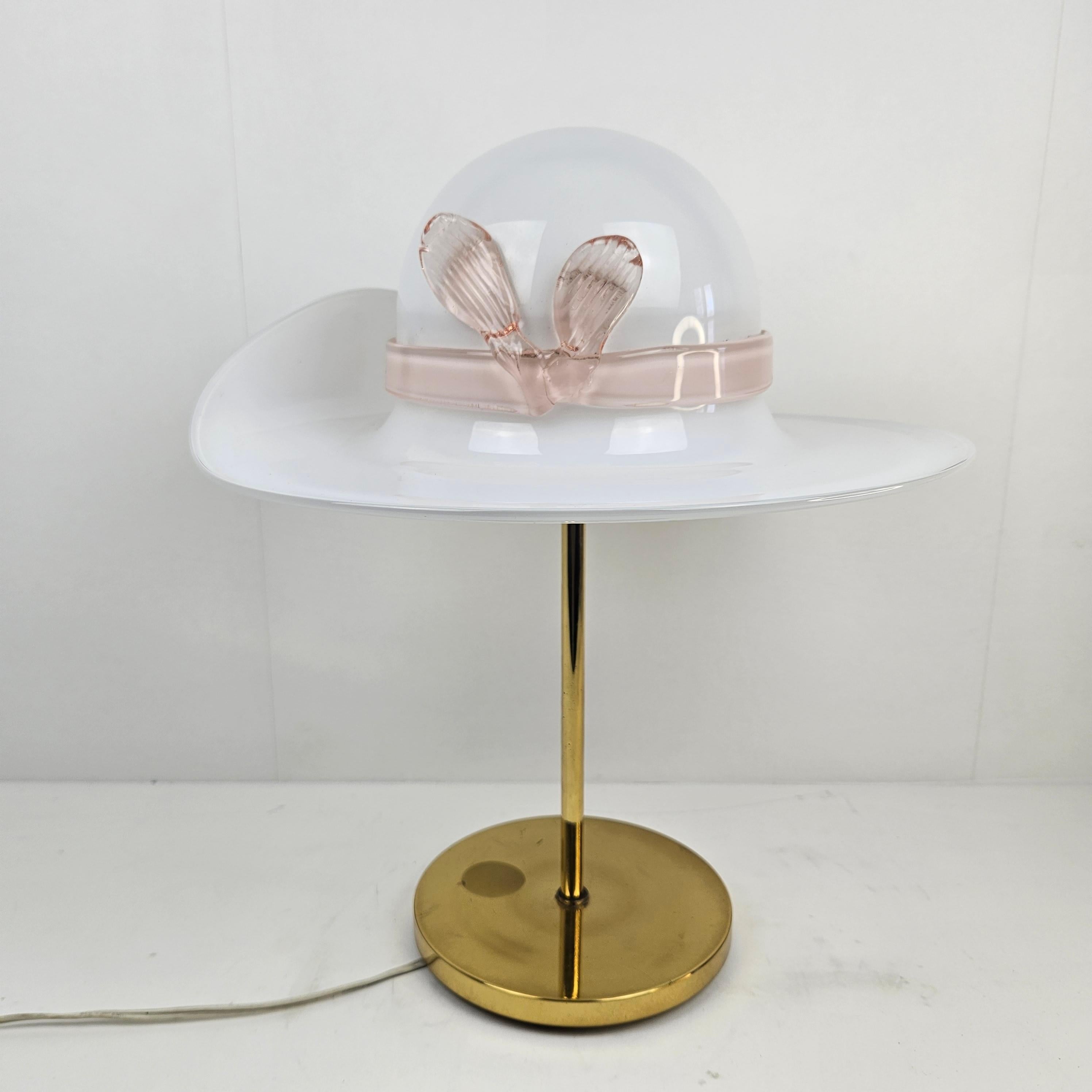 Very beautiful and cute table lamp.
This exceptional lamp is fabricated in the 70's in Italy.

The hand blown glass shade is made in Murano.
It has the shape of a lady's hat and it is made of very nice pink Murano glass.

The glass is in very good