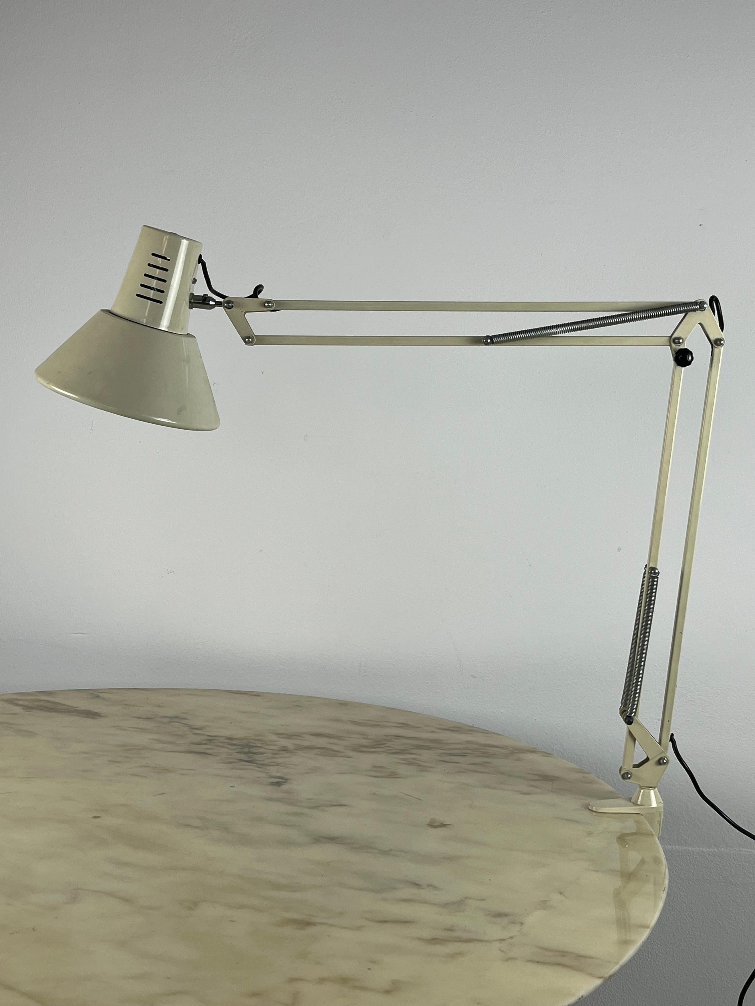 Extendable table lamp with clamp, made in Italy, 1970s.
Small signs of wear but still in excellent condition.The arm can be directed in any direction on the table. It reaches 100 cm from the clamp. The ceiling light has a diameter of 20 cm.