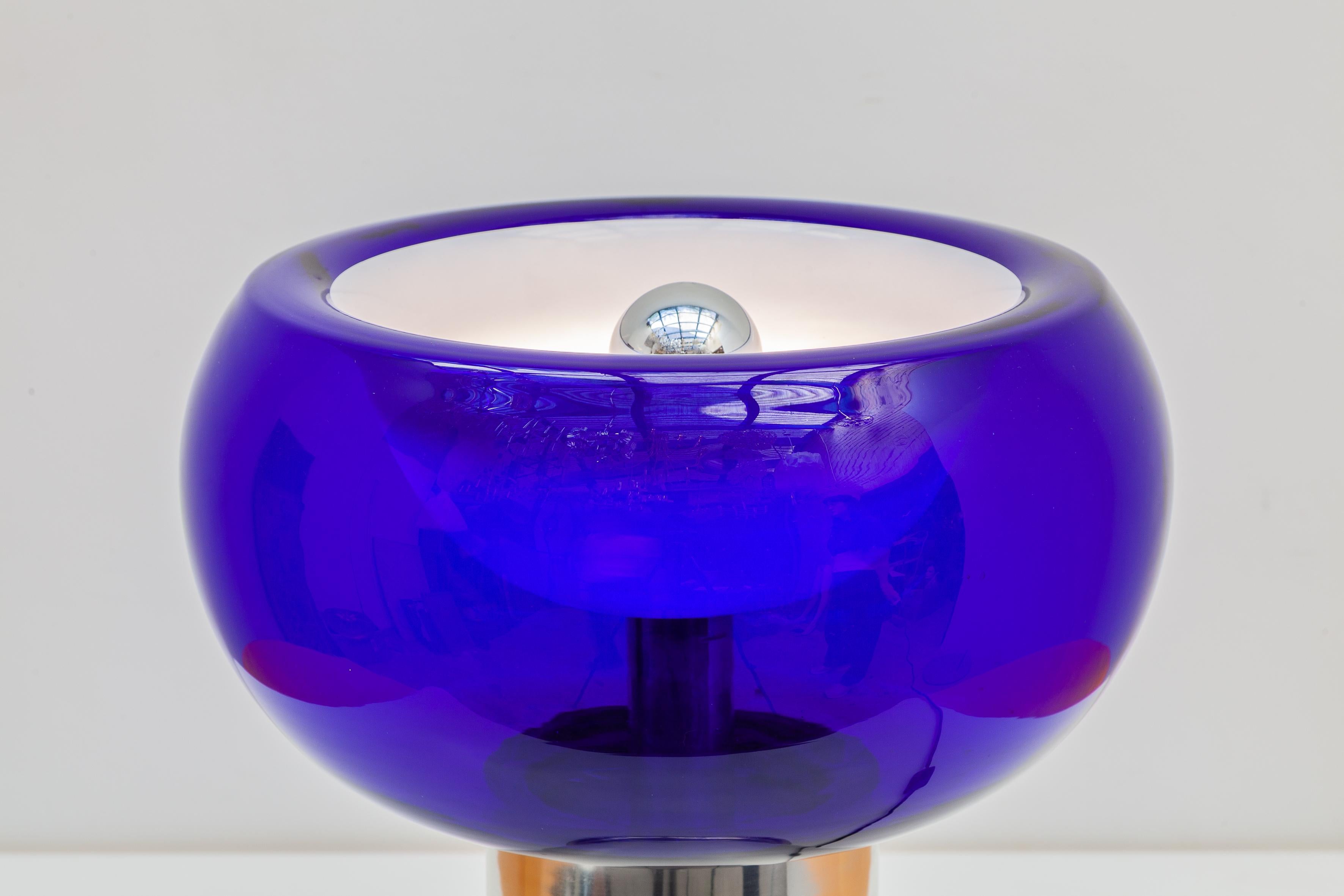 Mid-Century Modern 1970s table lamp designed by Doria, Germany. Bulb shade in blue glass with tubular chrome base with a metal lacquering shade inside and lit with one bulb that beautifully reflects the light.