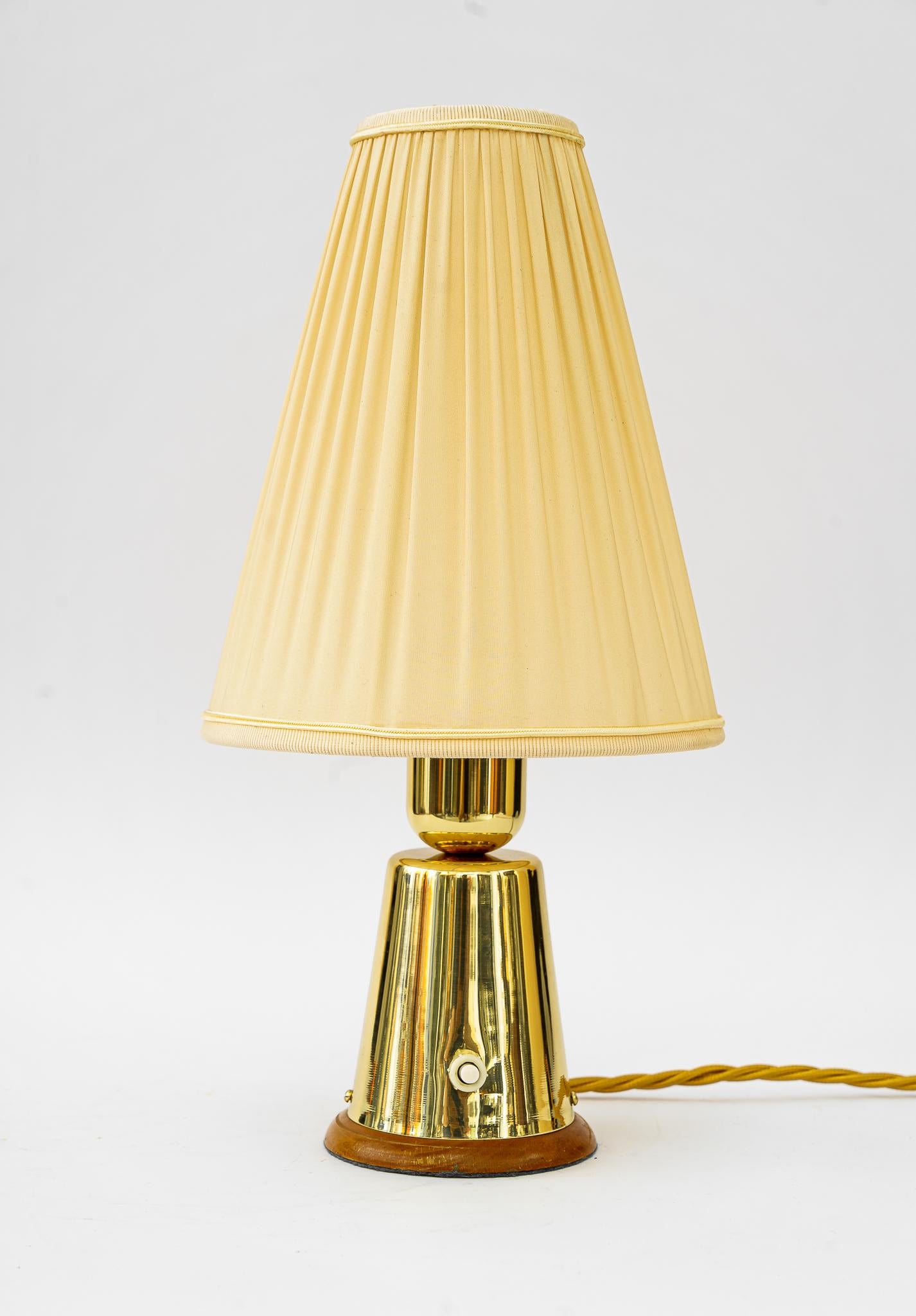Table lamp with fabric shade vienna around 1950s 
Brass polished and stove enameled
The fabric shade is replaced ( new )
Wood polished.