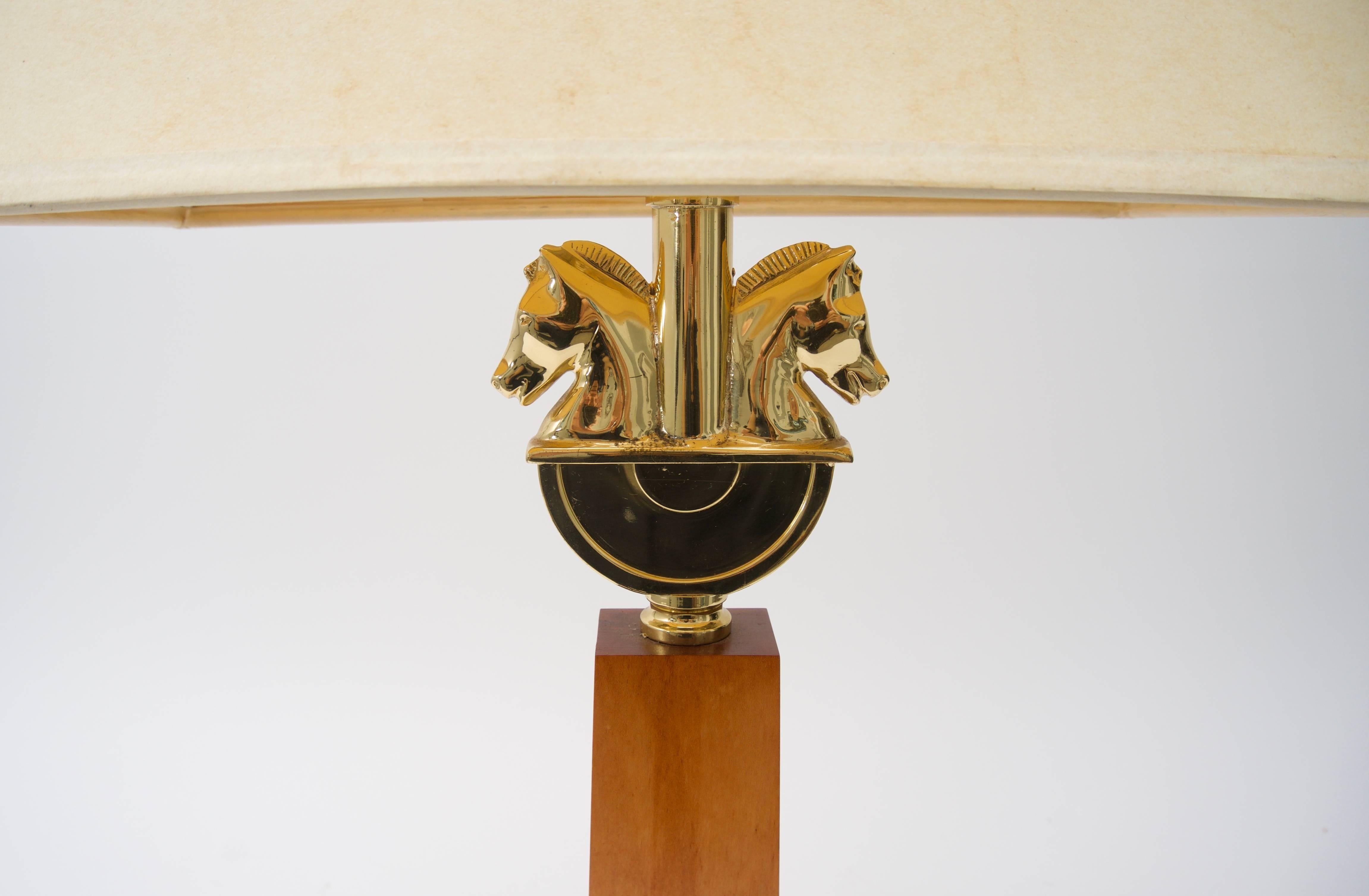 This stylish table lamp is very much in the style of pieces created in the style of Maison Charles with its equestrian motif of the double-horse head. The piece is cast, polished brass, maple wood and a hard-back paper shade.

Note: Height to top of