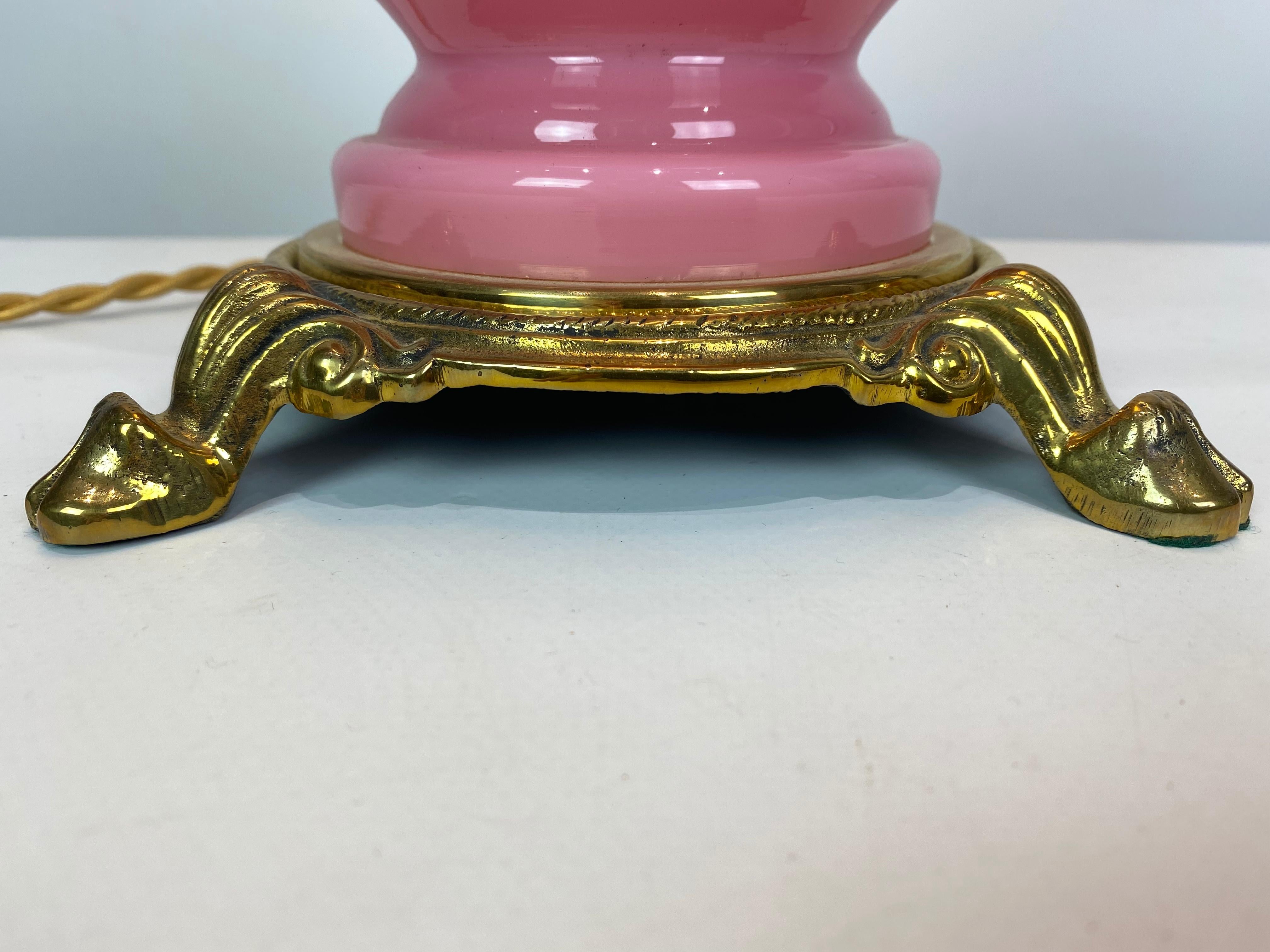 Lámpara de mesa con marco de cristal opalino rosa y pantalla de cristal opalino blanco, y pie de latón, de la cristalería Funen de los años 30. La lámpara está en gran estado antiguo y en estilo Jugend.
 