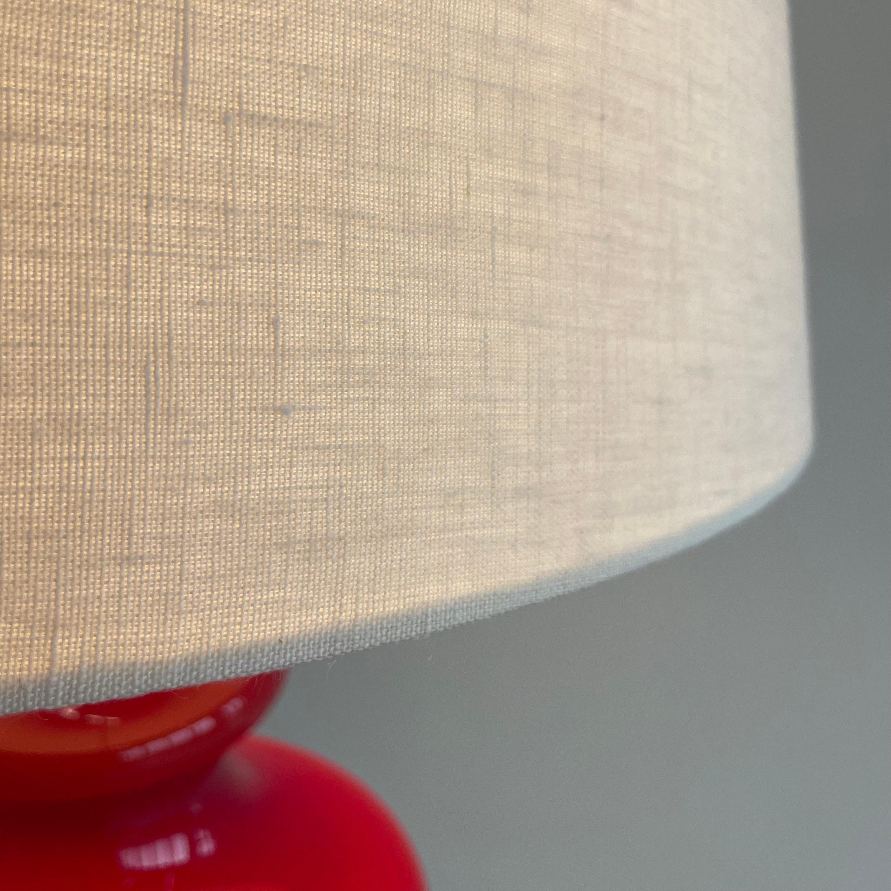 Table lamp with light cream coloured Lampshade. France, 1970s.

Large table lamp with illuminated coloured glass base and light cream coloured linen shade. One E27 fitting is in the base, and one E27 fitting is used for the lampshade. The switch