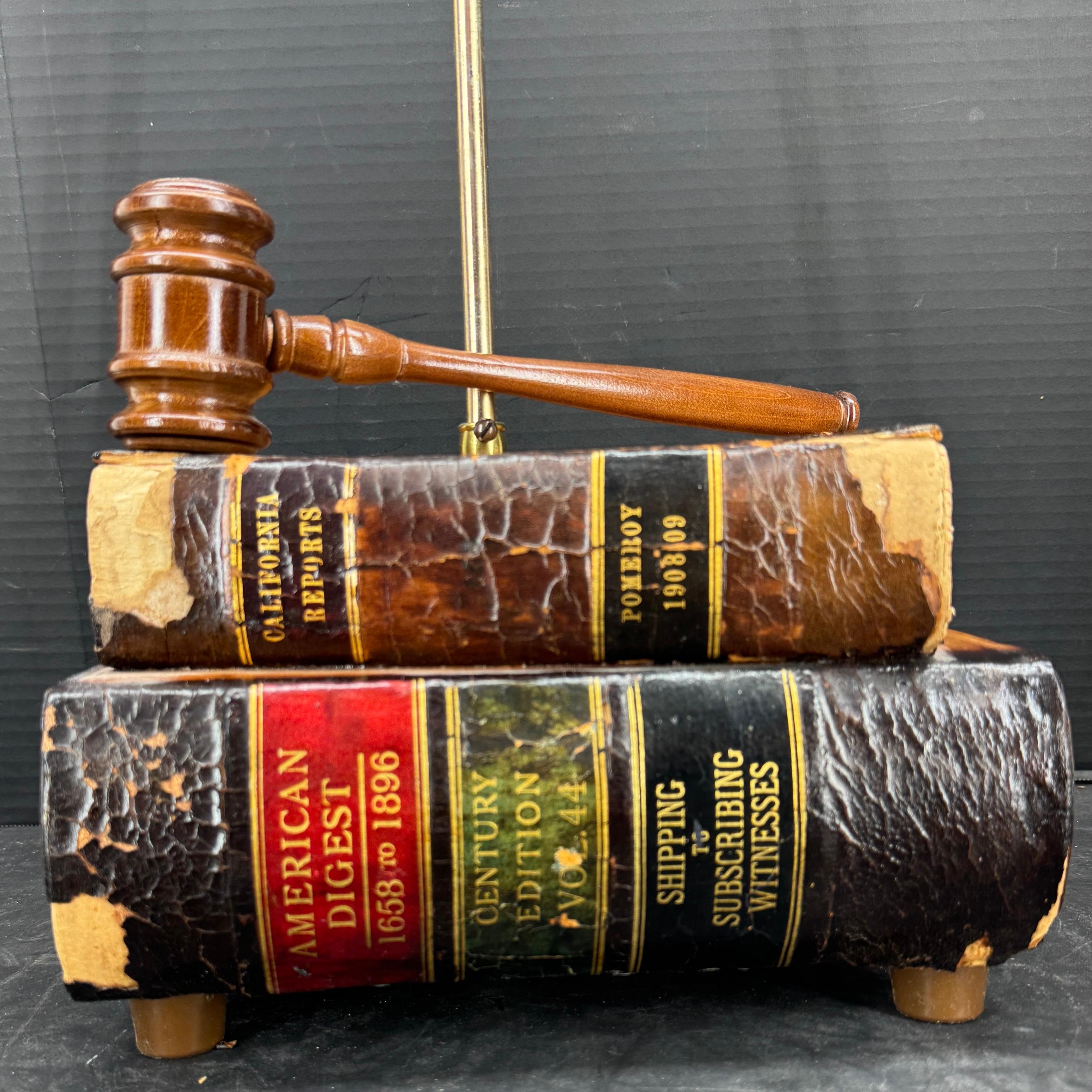 This charming lamp features leather books in a realistic form with a gavel on the top. The classic leather books are in warm tones with embossed details. This lamp certainly would make a statement and would look fantastic in a library, study or