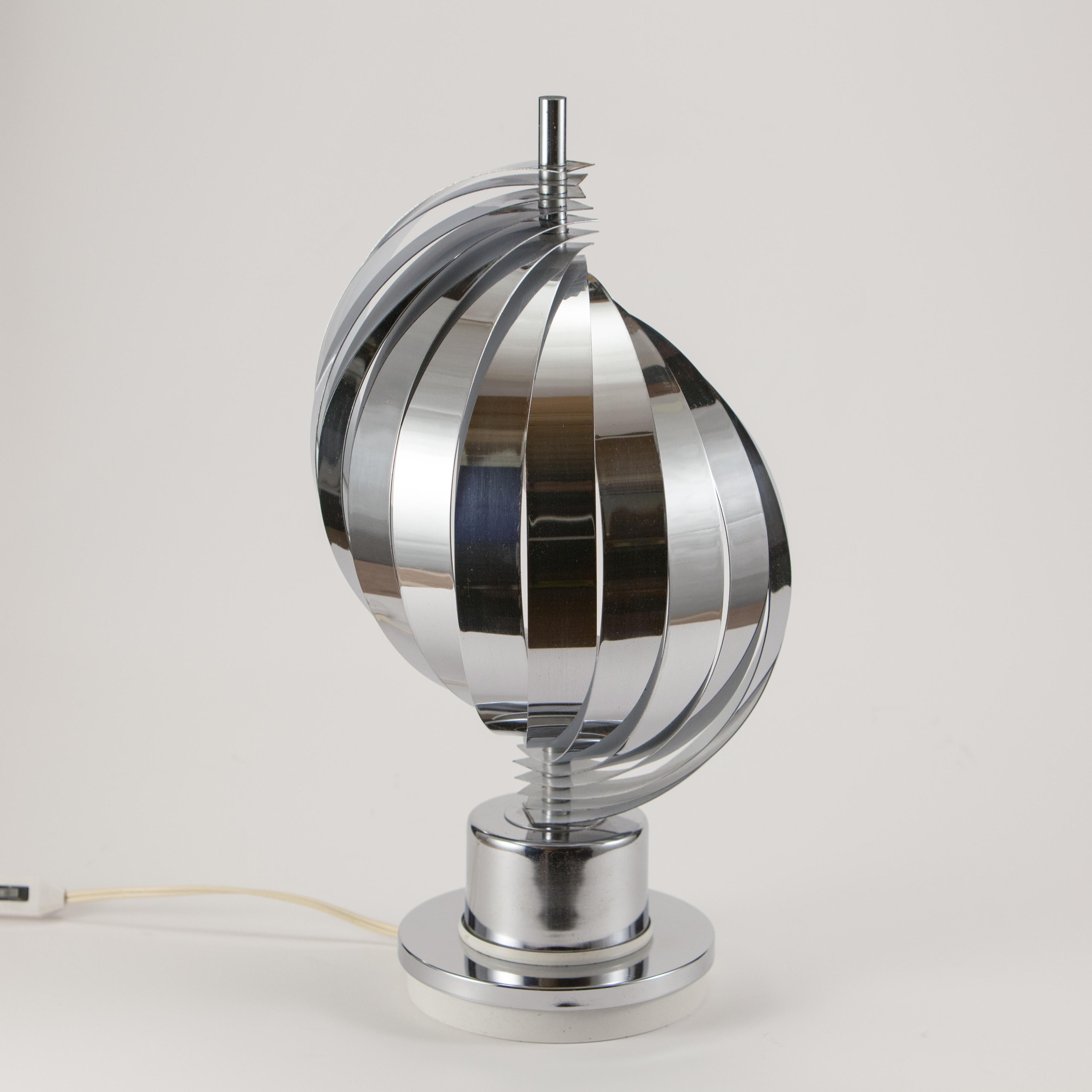 Tischlampe, hergestellt in den 70er Jahren. 
Die beweglichen Metallbänder laufen spiralförmig an einer zentralen Stange herunter. Die Lampe hat eine E14-Fassung.
Empfohlen wird eine 6,5-Watt-LED-Birne, die 40 Watt entspricht. Eine Glühbirne ist