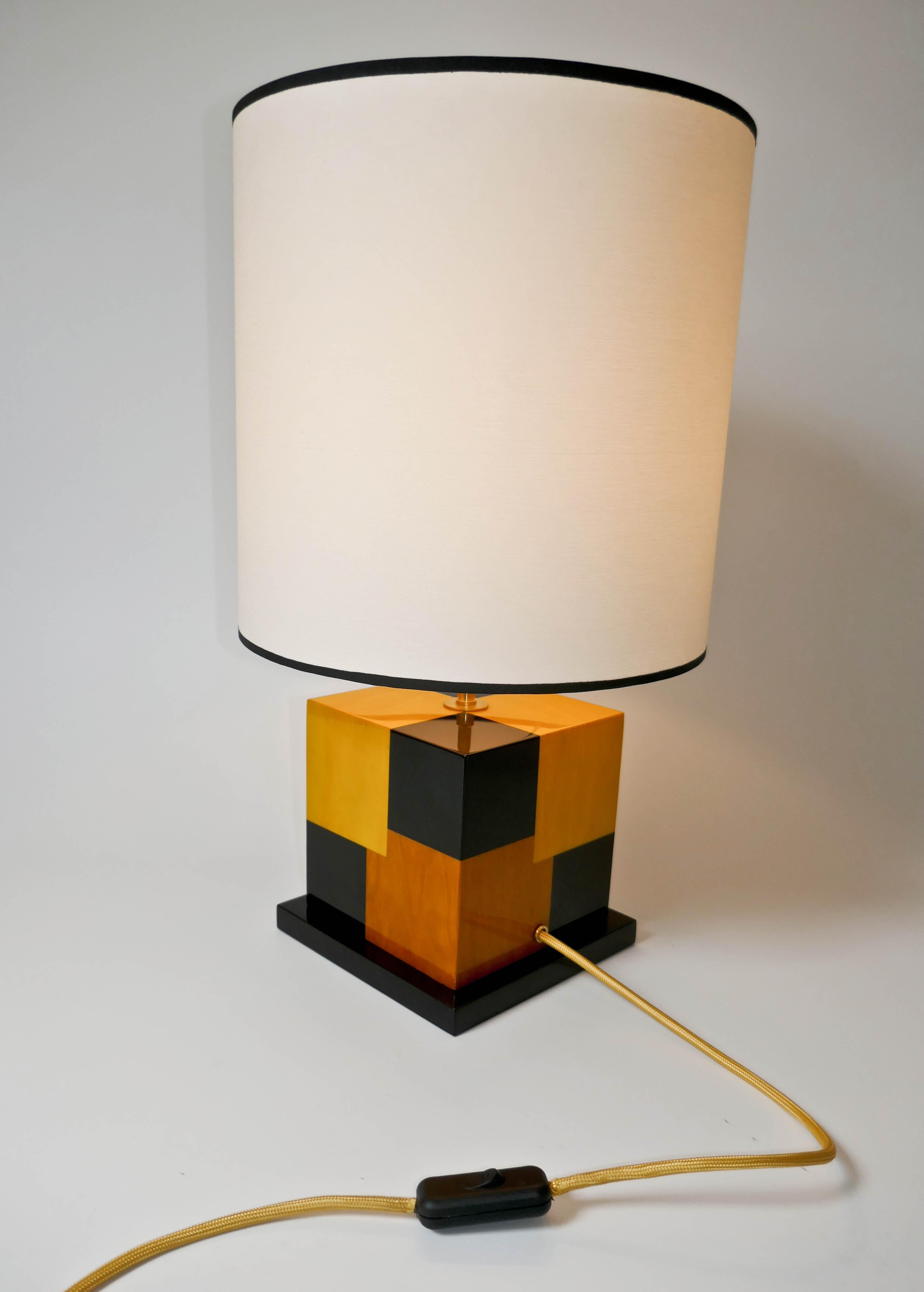 Table lamp in tinted black, light and dark Yellow sycamore marquetry designed by Aymeric Lefort.
Carefully build in our Parisian workshop this lamp has a Kinetic effect using the different colors to create an impression of deepness. The lamp is