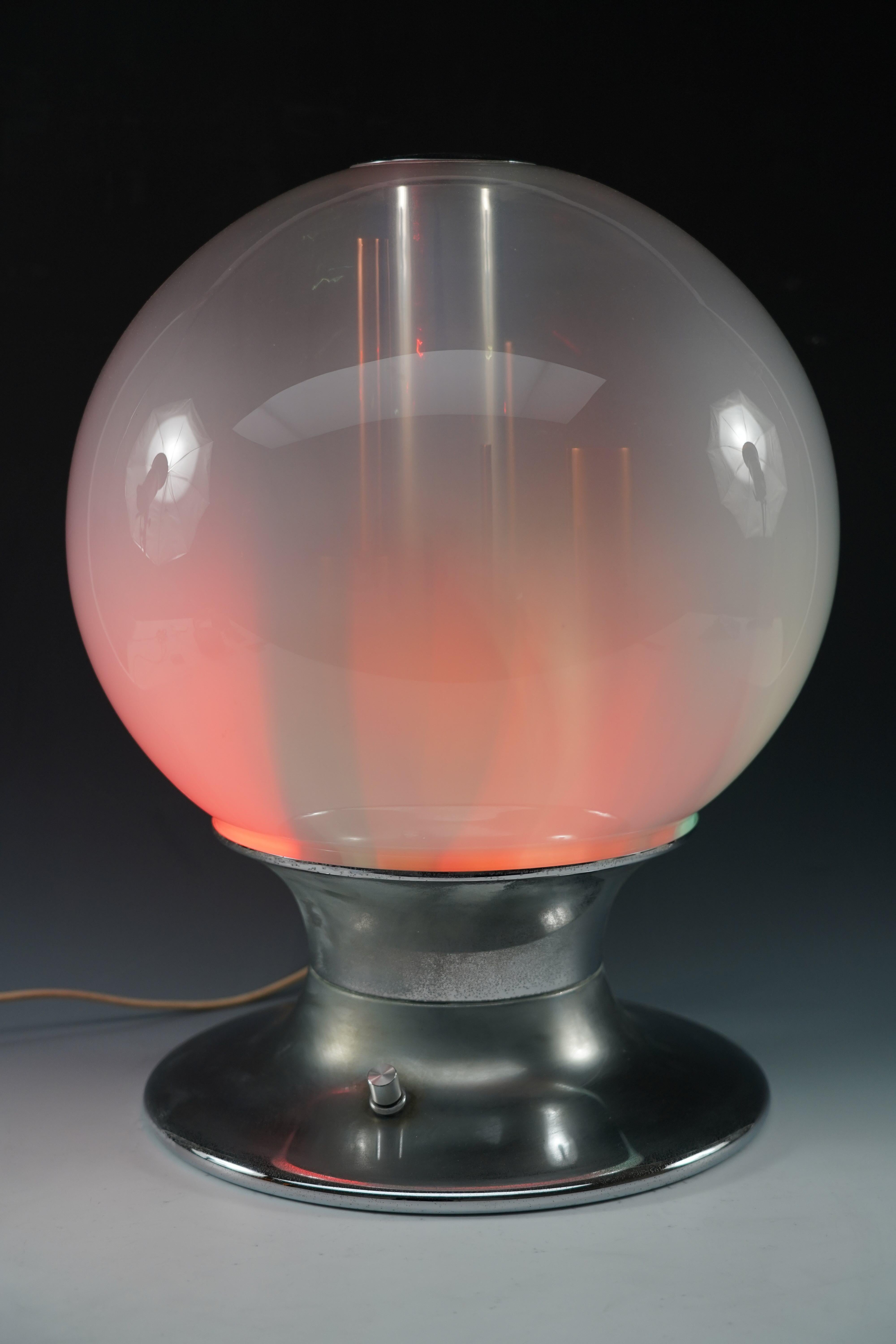 Superb table lamp composed of a blown Murano glass globe and a chromed metal base, from the 1970s, and produced by “Selenova”.
It is made up of 4 bulbs, green, red, yellow and white which diffuse lighting of variable intensity via a dimmer.
This