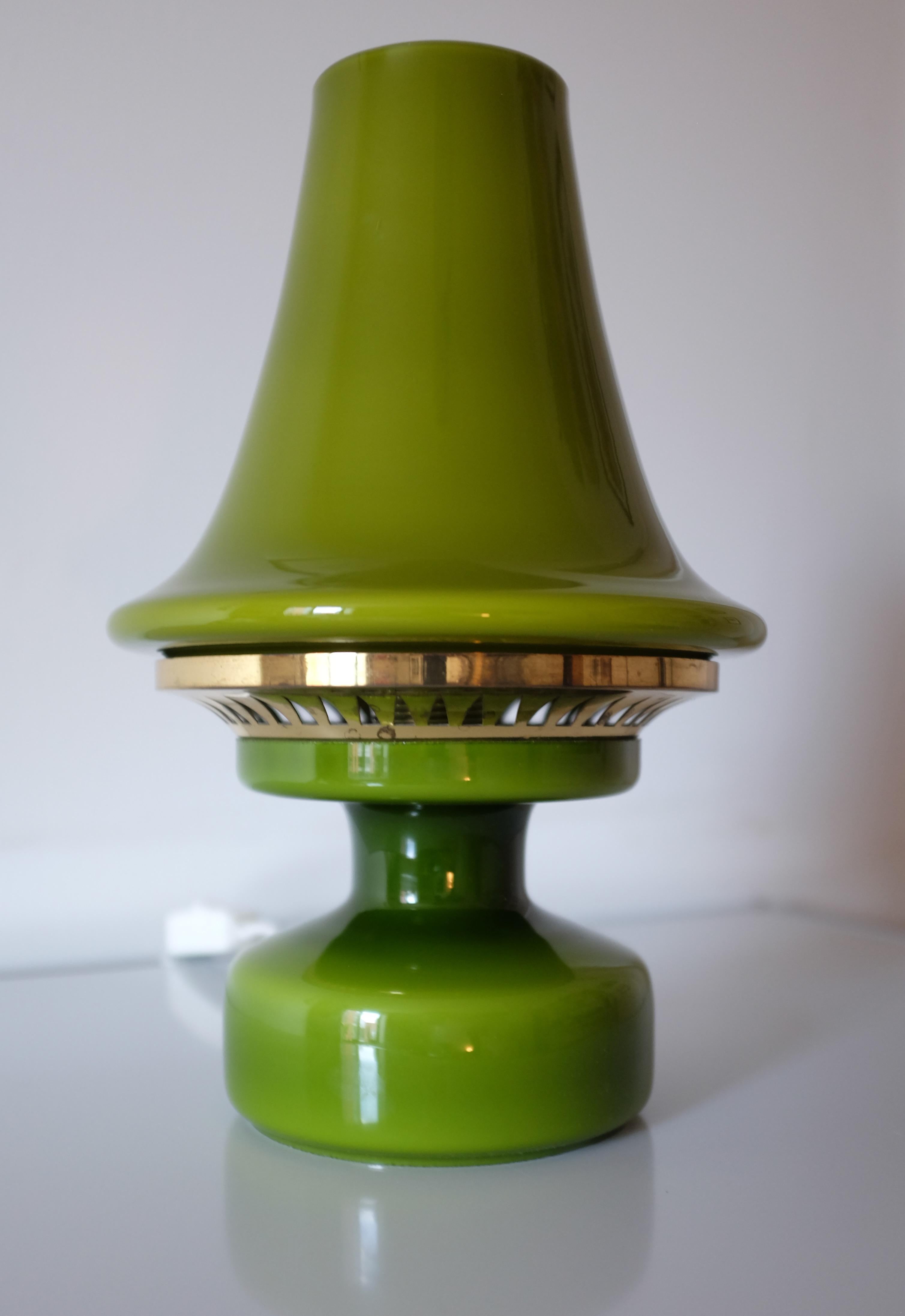 Impressive green opaline glass and brass table light by Hans-Agne Jakobsson for AB Markaryd. Round glass base with a brass accent in a graphic pattern topped with a cone shaped glass shade. All in the same dark lime colored opaline glass. A great