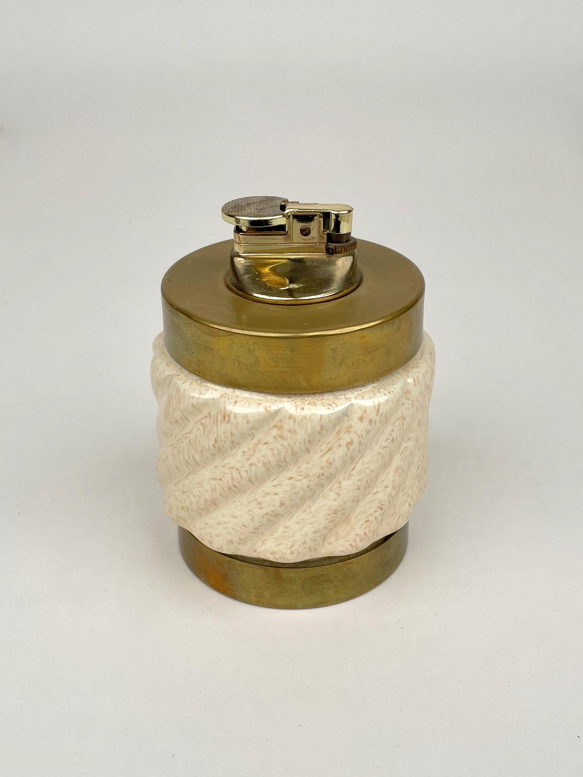 Table lighter in beige ceramic and brass by the Italian designer Tommaso Barbi. Made in Italy in the 1960s.

The lighter is functioning and Barbi's engraved initials are still visible on the bottom, as shown in the pictures.