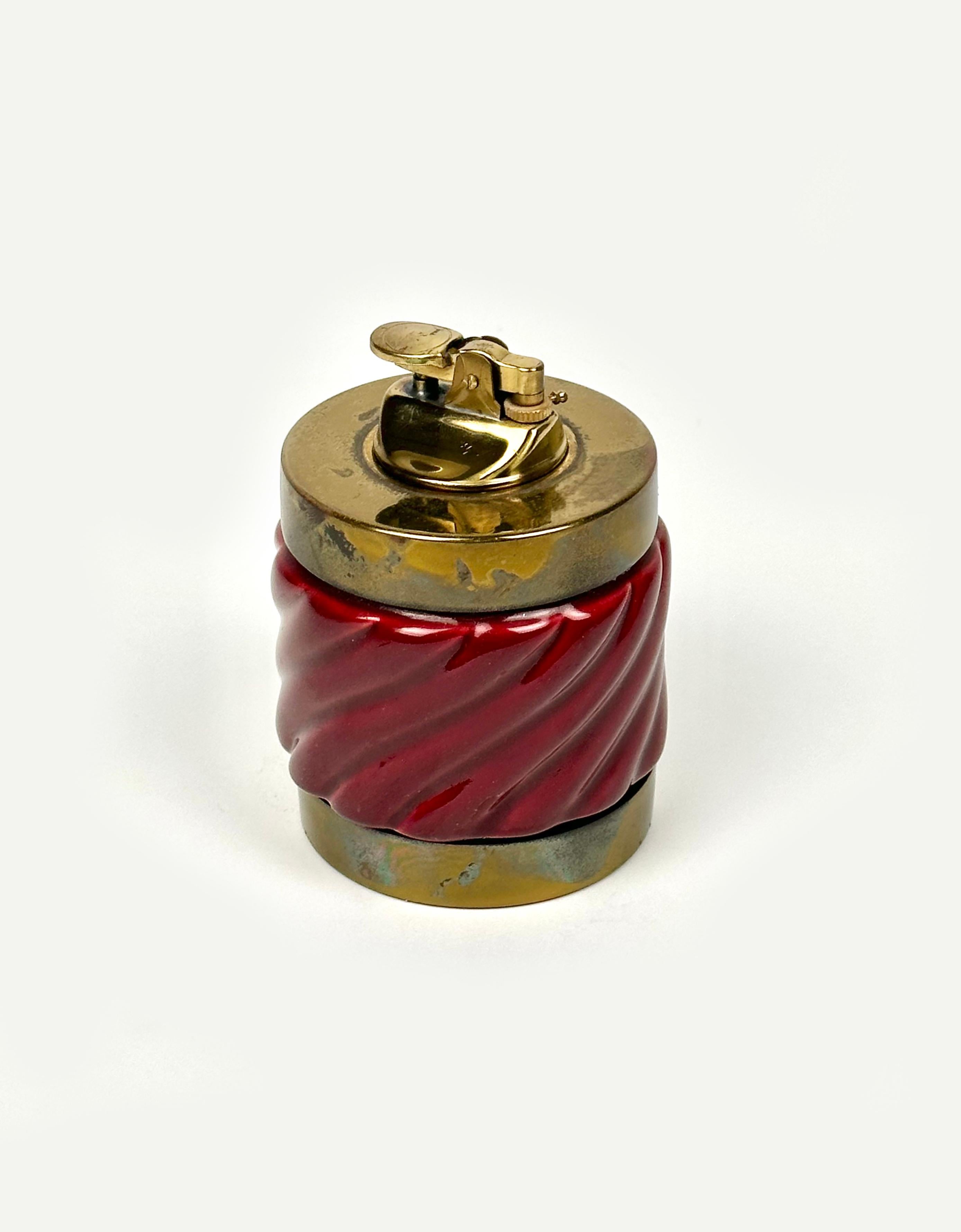 Table lighter in bordeaux ceramic and brass by the Italian designer Tommaso Barbi. 

Made in Italy in the 1970s. 

The lighter is functioning and Barbi's engraved initials are still visible on the bottom, as shown in the pictures.

Perfect