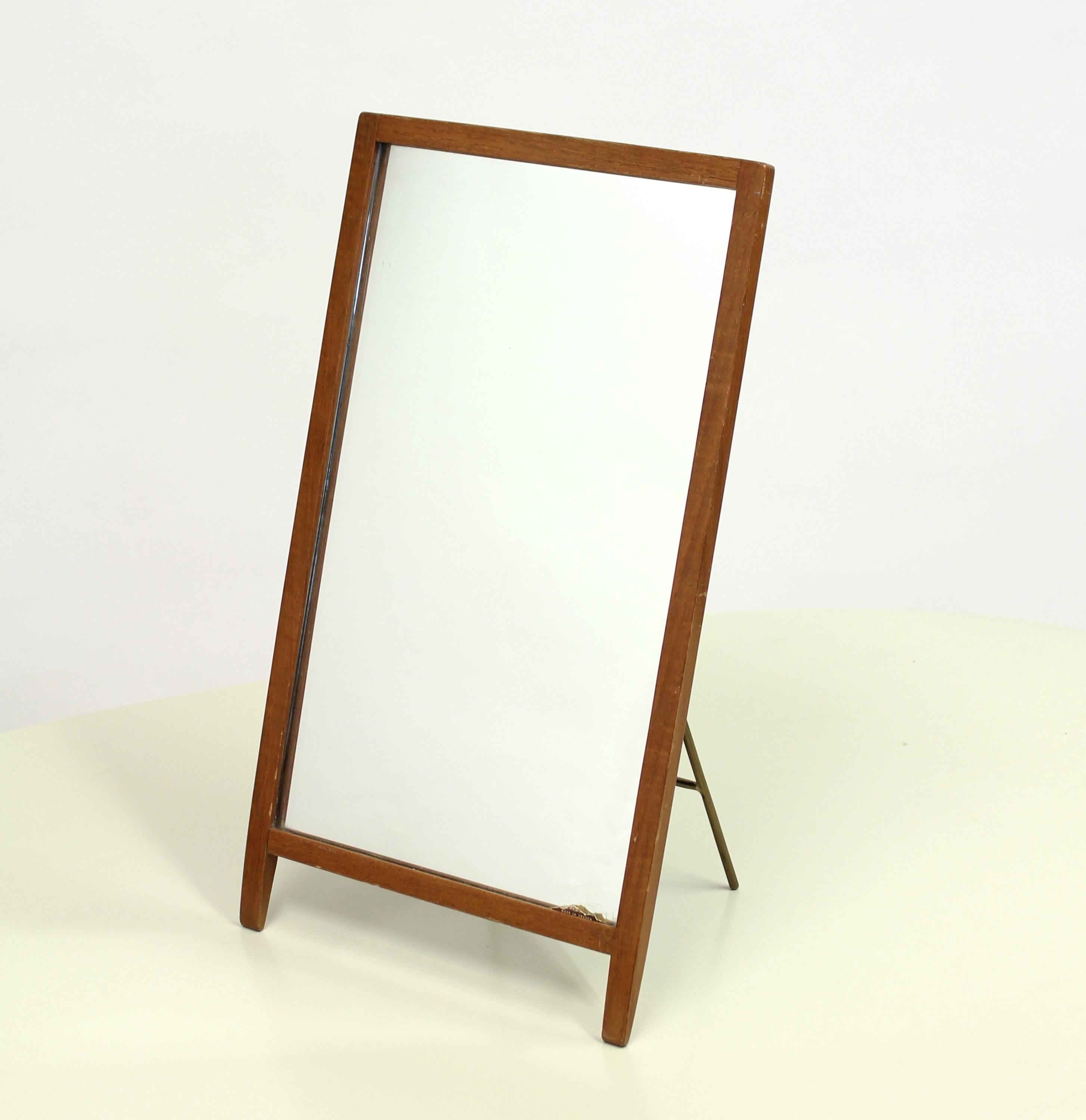 Very rare table mirror designed by Hans-Agne Jakobsson for his own company Hans-Agne Jakobsson AB Markaryd in the 1960s. Frame is made of teak and back with original black painted wood with foldable brass stand. Little bit of the original makers