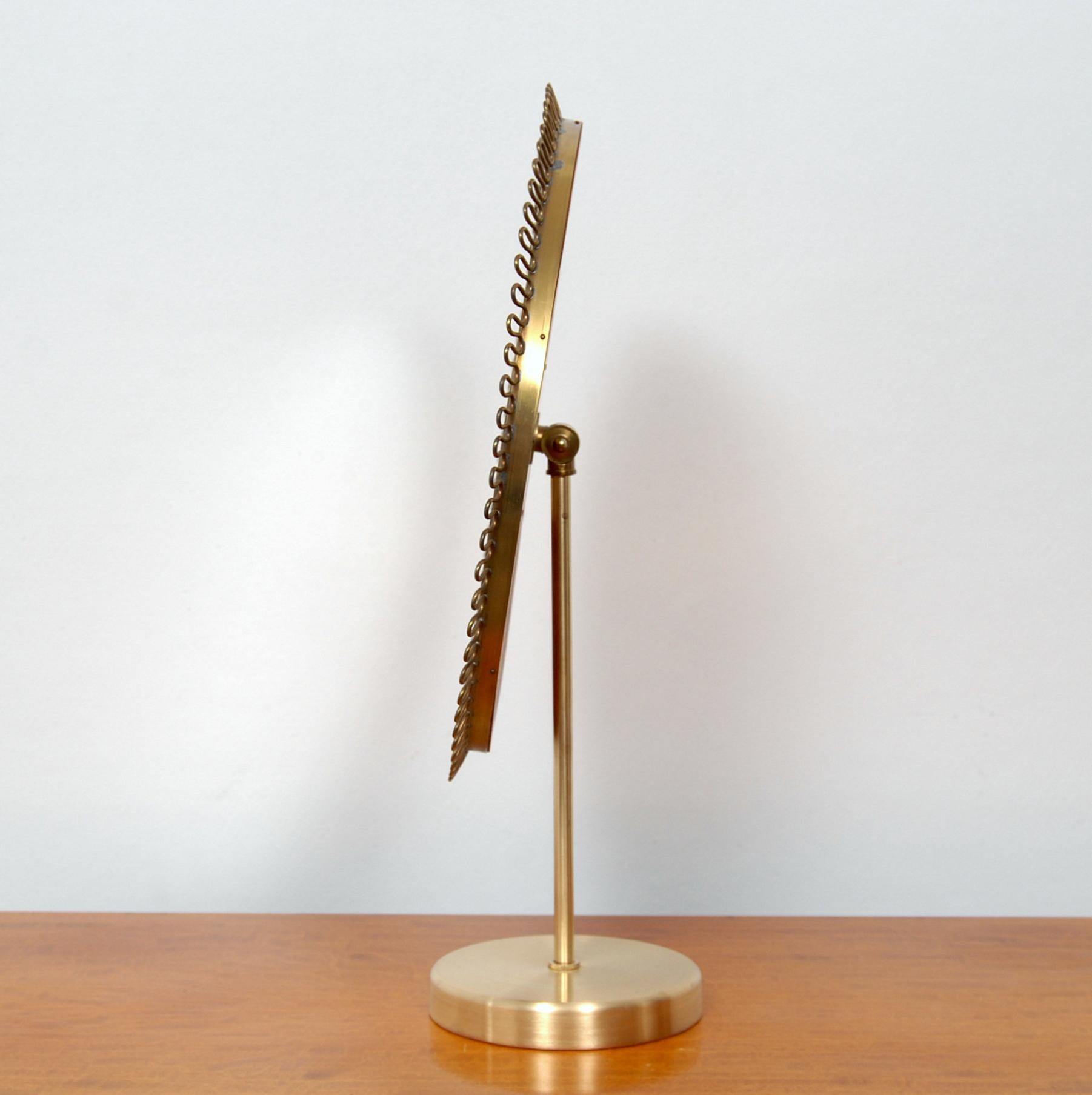 Table vanity mirror designed by Josef Frank produced by Firma Svenskt Tenn during the 1950s. Brass with a teak back. Adjustable angle.

         