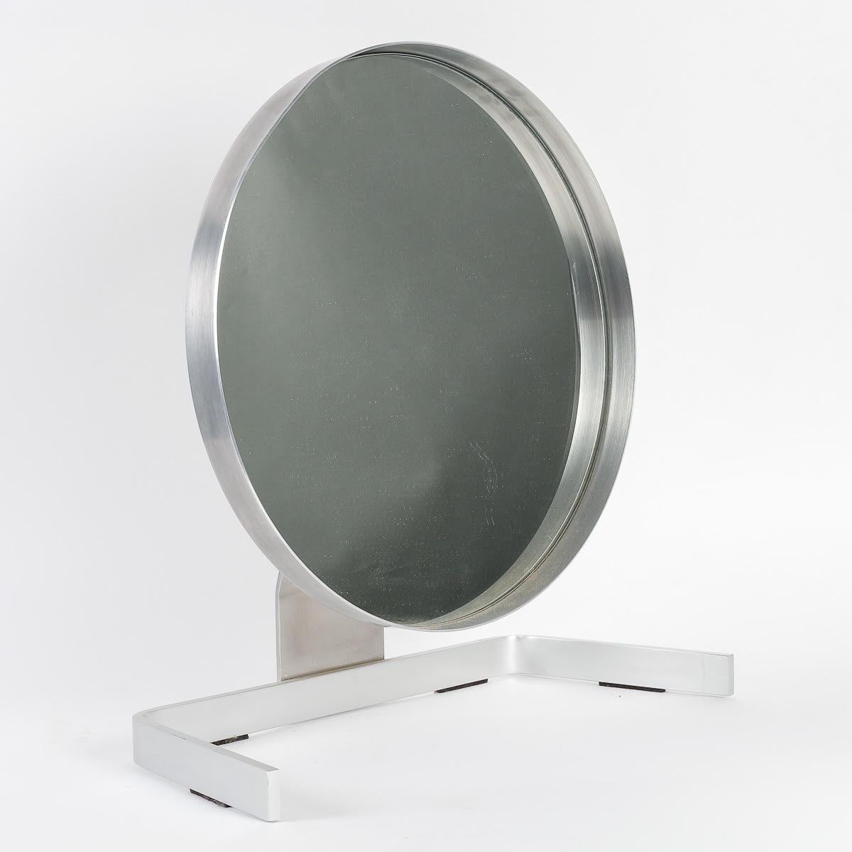 Table mirror by Pierre Vandel, 1970, Steel and mirror.

Steel and mirror table mirror by Pierre Vandel from the 1970s. Slight deformation of the rounded part of the mirror.  
h: 47,5cm , w: 44cm, d: 22cm