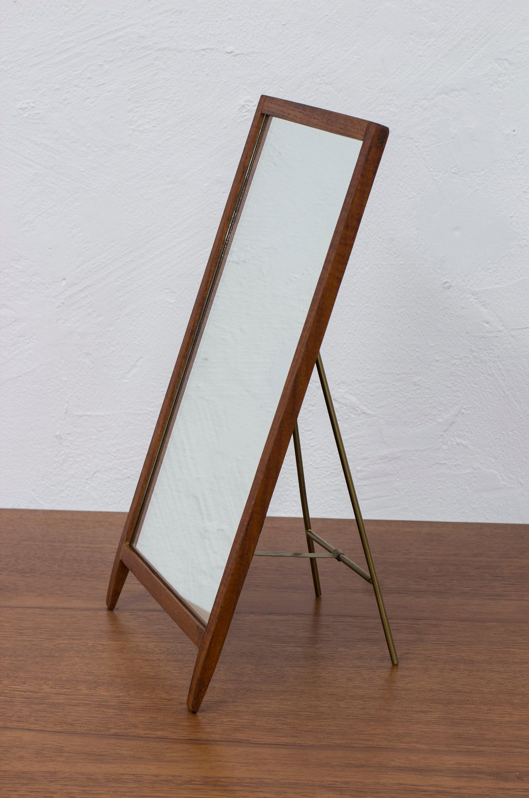 Table mirror designed by Hans-Agne Jakobsson. Early production from his period in Åhus, 1950s. Made from solid teak with brass stand and black lacquered wooden back part. Very good vintage condition with light age related wear and