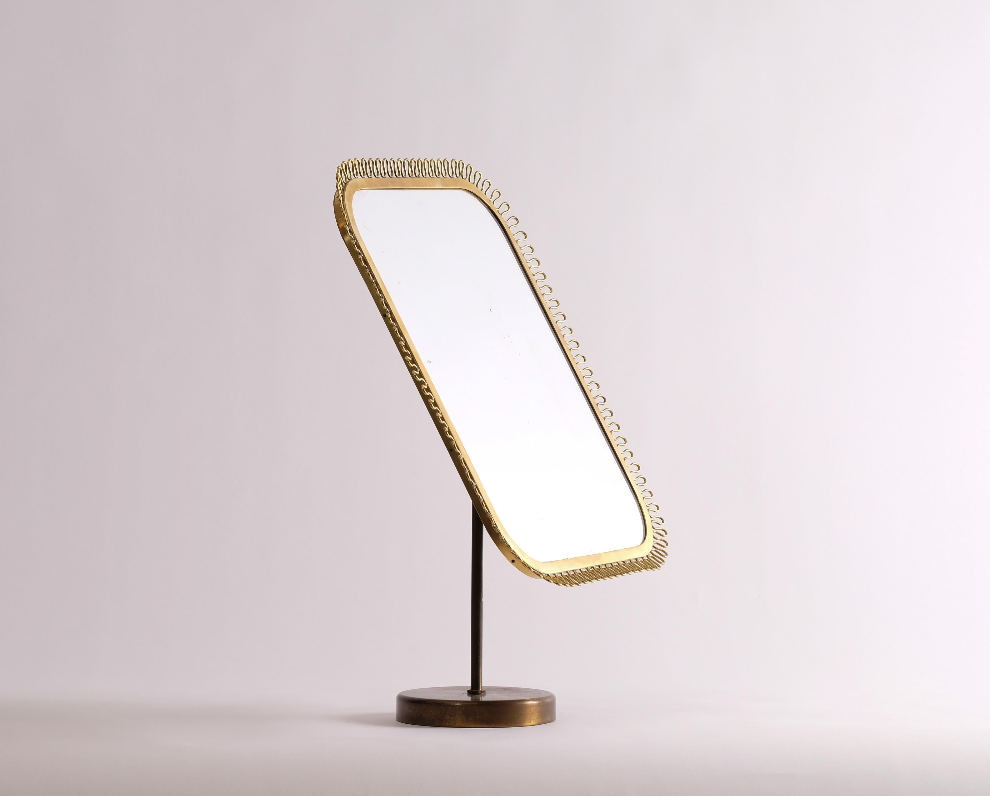 Table mirror in brass, possibly manufactured by Nordiska Kompaniet, 1950s.
Brass, wave-shaped border decoration. Adjustable.