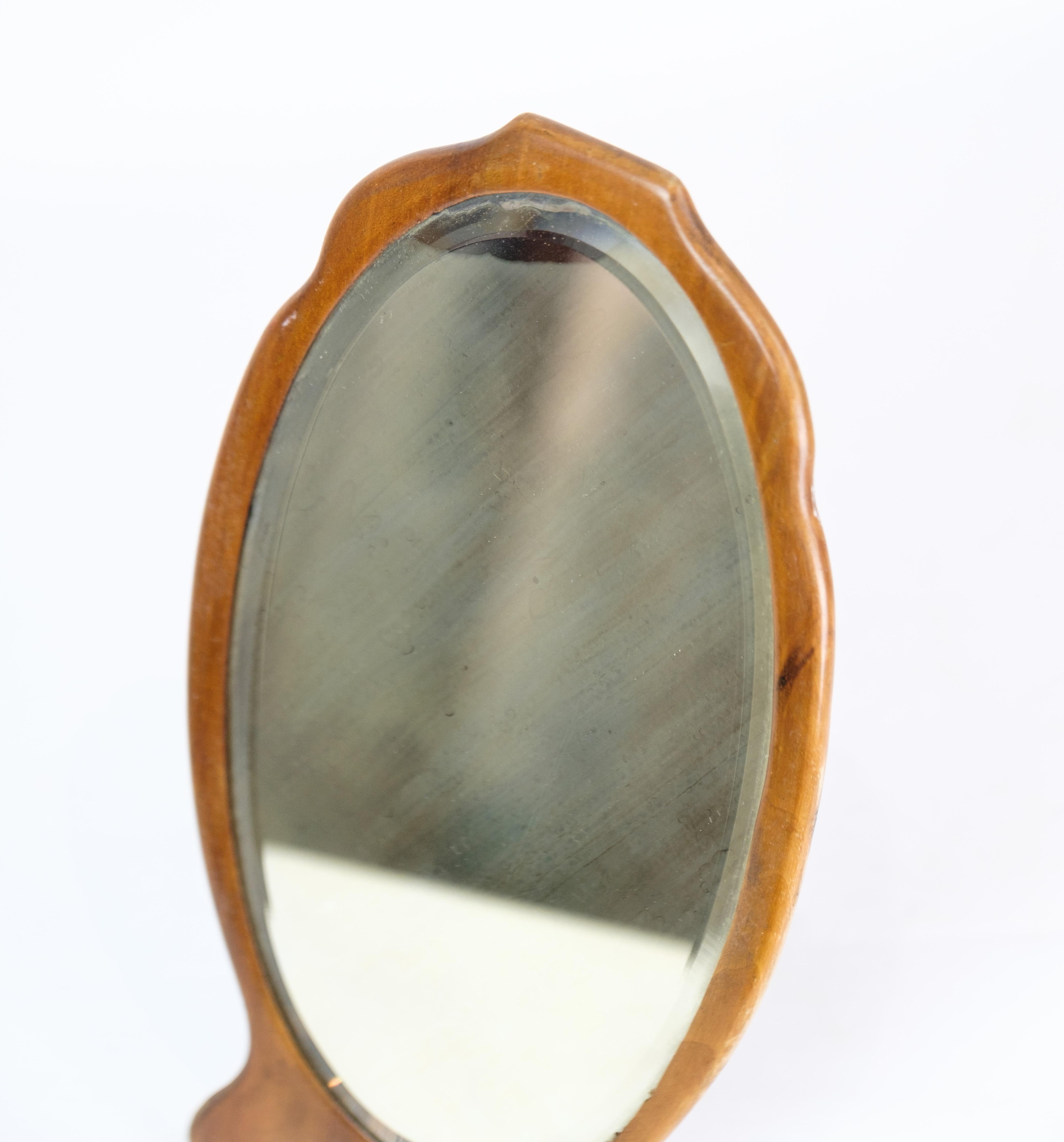 Small table mirror in walnut wood with small metal foot from around the 1880s.
Dimensions in cm: H:30 W:15.5.