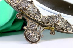 Table mirror with silver applications on wood and resting on two cut-out feet