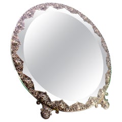 Table mirror with silver applications on wood and resting on two cut-out feet