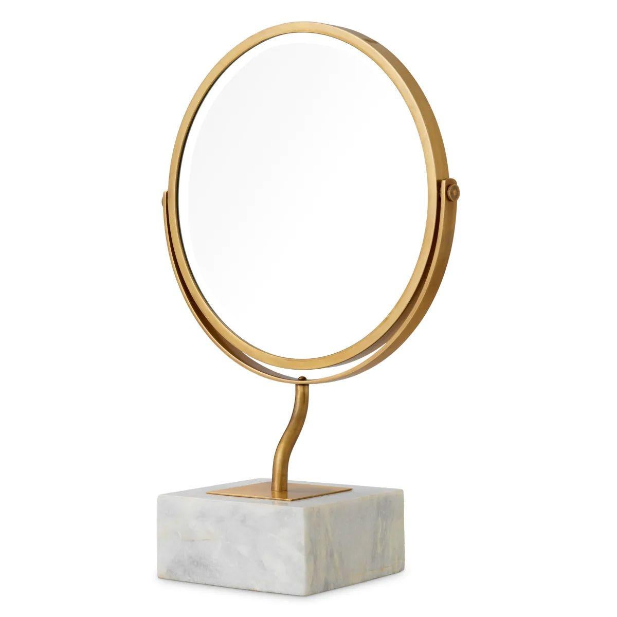 This table mirror features a white marble base and a vintage brass finish, creating a refined accessory that enhances any interior. The table mirror combines a stable marble base with a warm metallic tone, offering both elegance and durability.