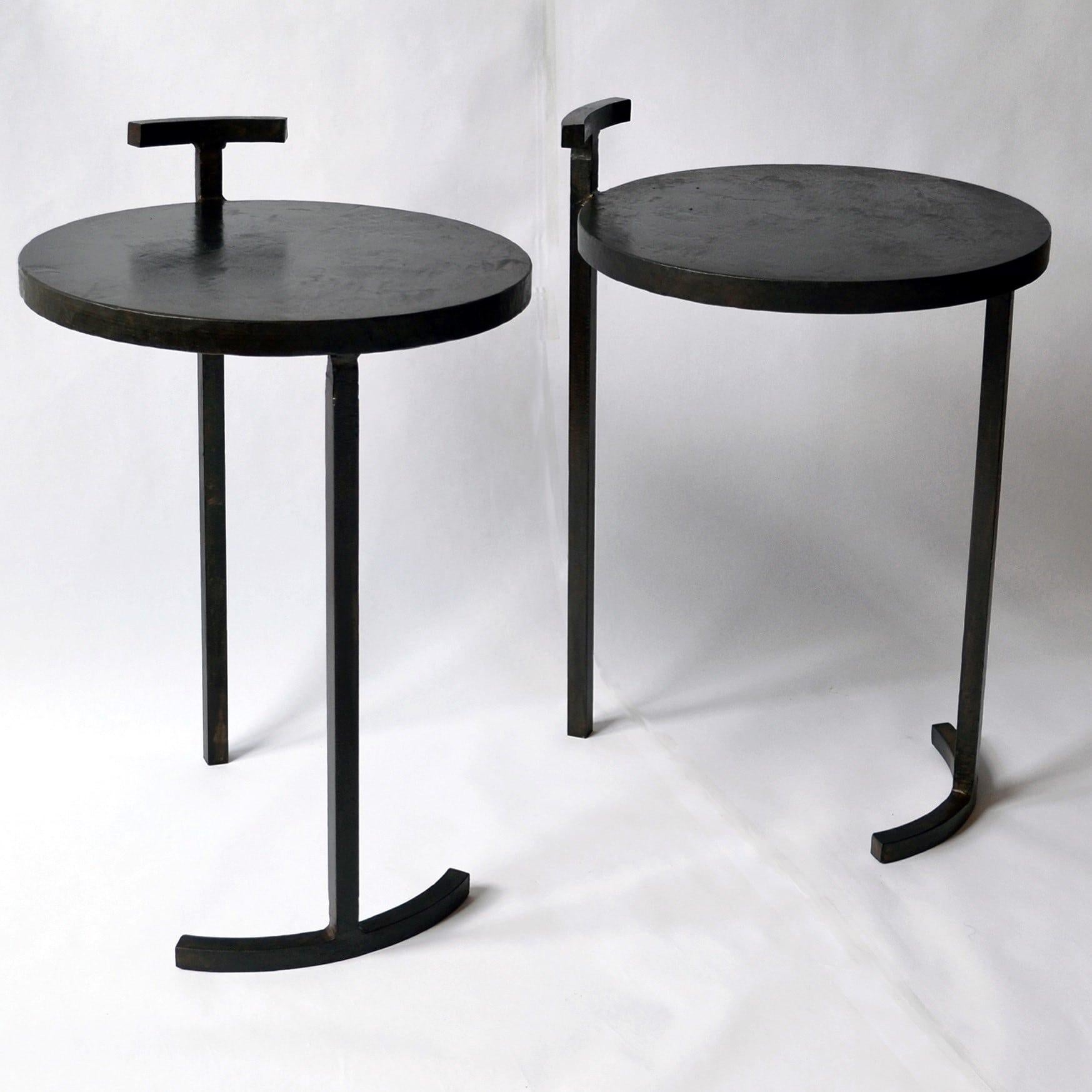 A striking design composed of two separate side tables. Each table has only two legs.

These side tables are made from cast blackened and waxed steel. A uniquely designed frame allows a 1 inch thick, cast steel, circular top to balance on two