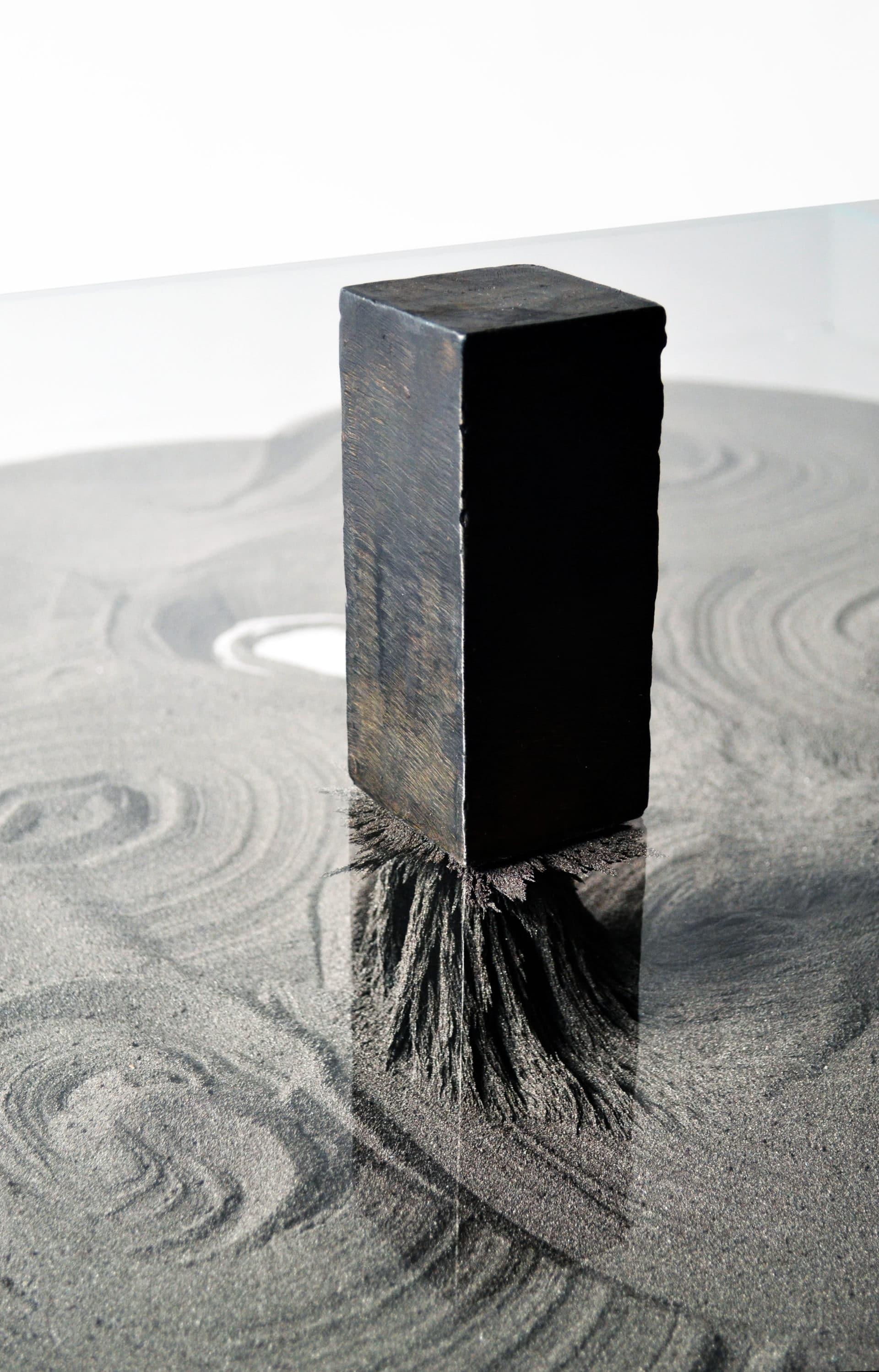 Hand-forged blackened steel, fine iron powder, rare earth magnets, starphire glass, and an assortment of magnetic objects. The objects are able to be moved freely will shift the iron powder around as they are moved upon the surface of the