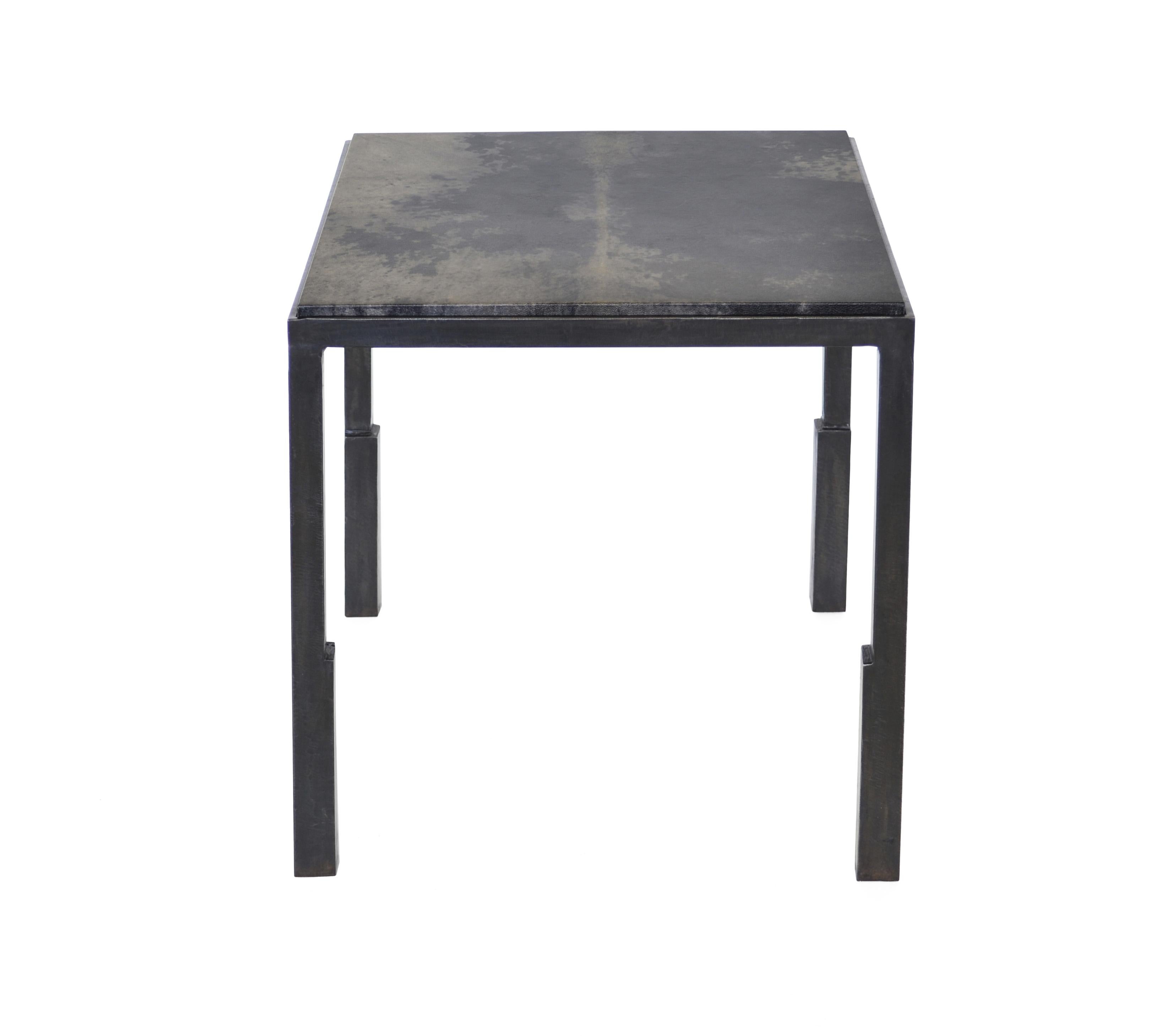 A blackened steel table frame is hand-sculpted into unique geometries. The table can be customized by choosing a shagreen or parchment tabletop.

Blackened steel with wax finish and shagreen or parchment top.

Handmade in New York.
 