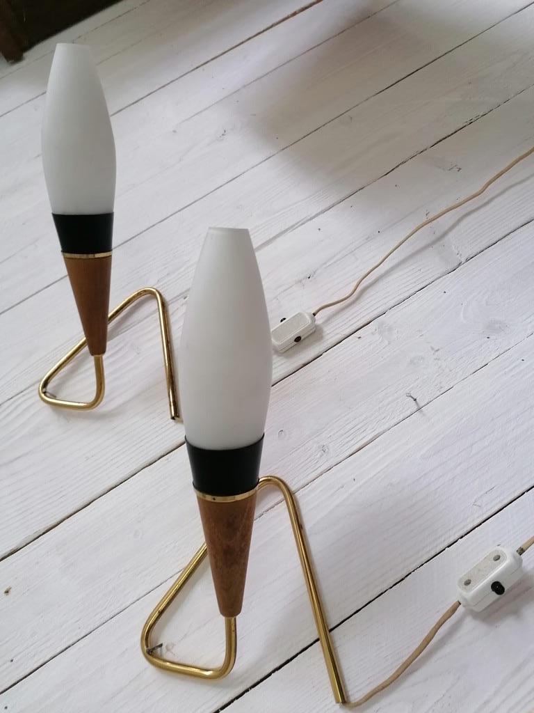 A pair of table or wall lamps. Brass foot fitted each with E14 socket on a teak cone and opaline glass shade. Made by Rupert Nikoll in Austria in the 1950s.