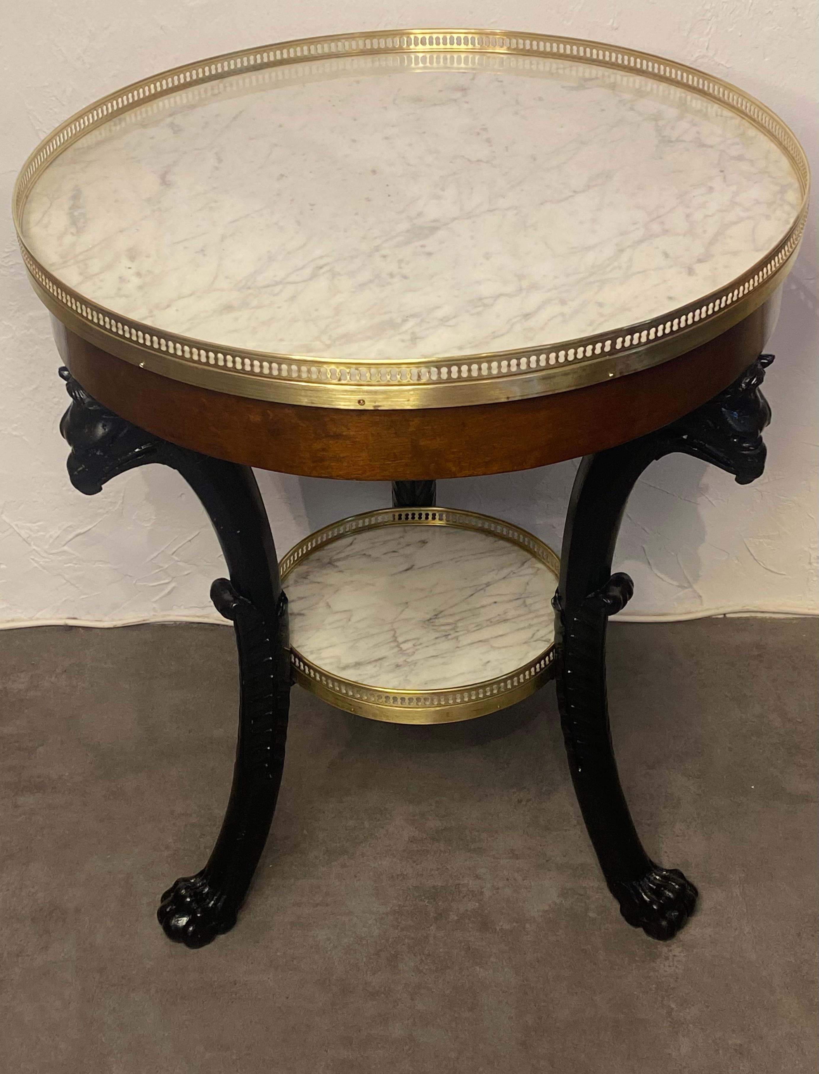 Tripod pedestal table in mahogany veneer.
The white marble top surrounded by openwork brass rests on 3 bronze-patinated mahogany legs with griffin heads ending in lion claws. An intermediate shelf at the crotch.
Very fine Parisian production from
