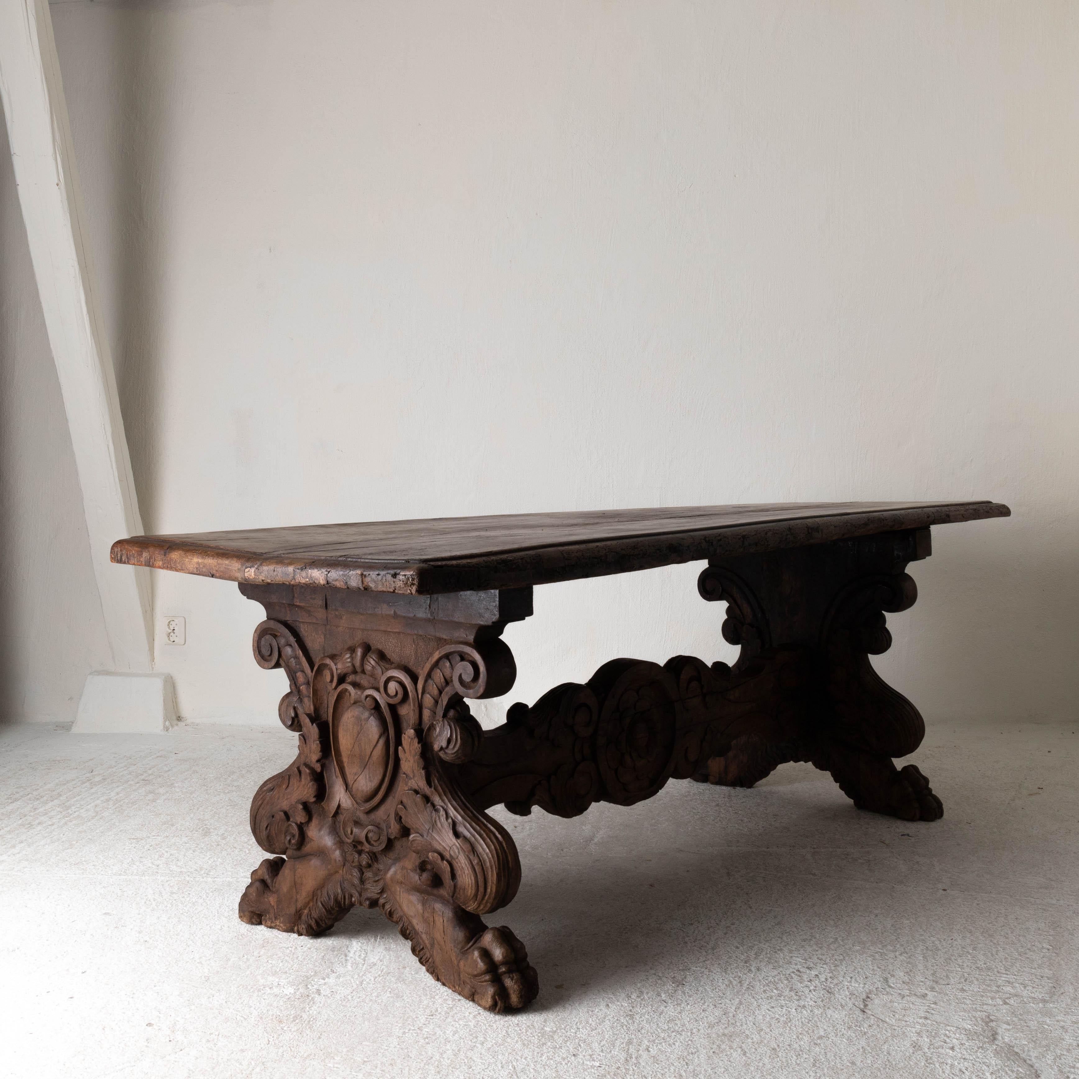Table rare Baroque Italian oak patina crest details, Italy. A rare and large table made during the Baroque period in Italy. Stunning patina of the solid oakwood. Each side of the base has a crest detail. Feet in the shape of lion paws and decorated