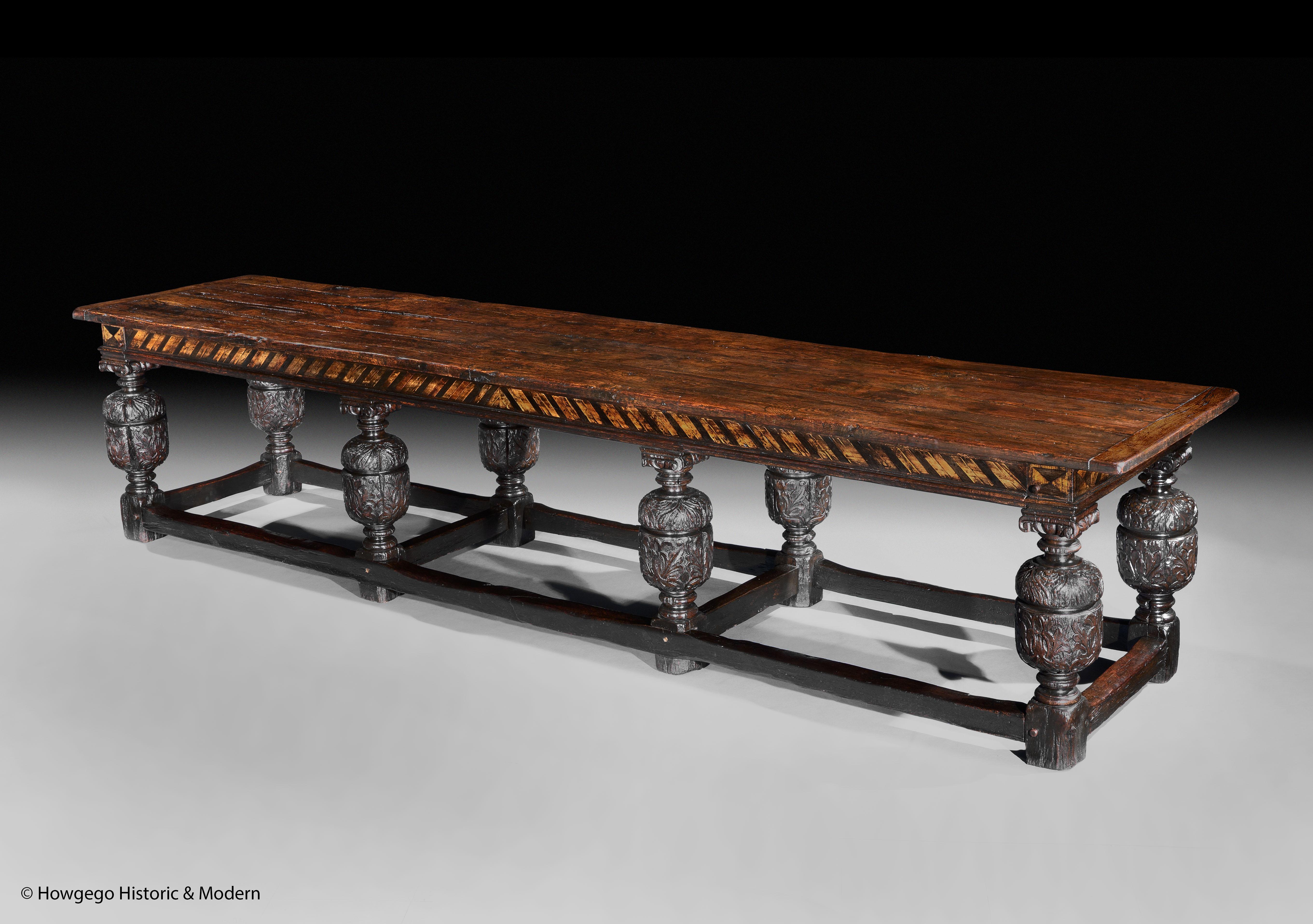 A MASSIVE, 18 SEATER, LATE-19TH CENTURY, ANTIQUARIAN, REFECTORY TABLE, with an elm top, boxwood and parquetry frieze and oak base 3.68m 145