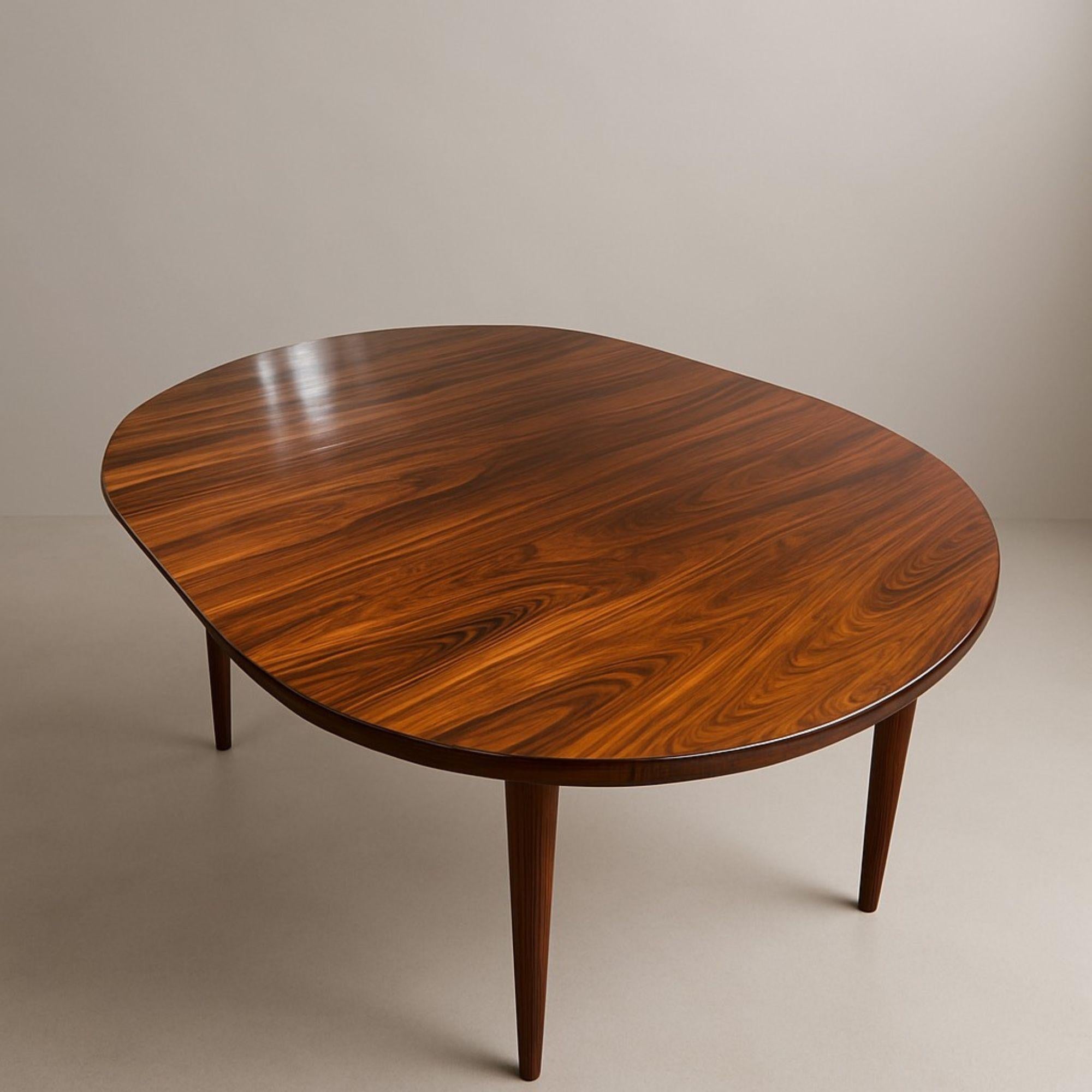 Très belle table de salle à manger en palissandre, avec ses trois rallonges et son pied central amovible, elle peut accueillir jusqu’à 12 personnes. 
Ses 3 rallonges permettent d’adapter la longueur de la table : ronde elle mesure 115 cm de