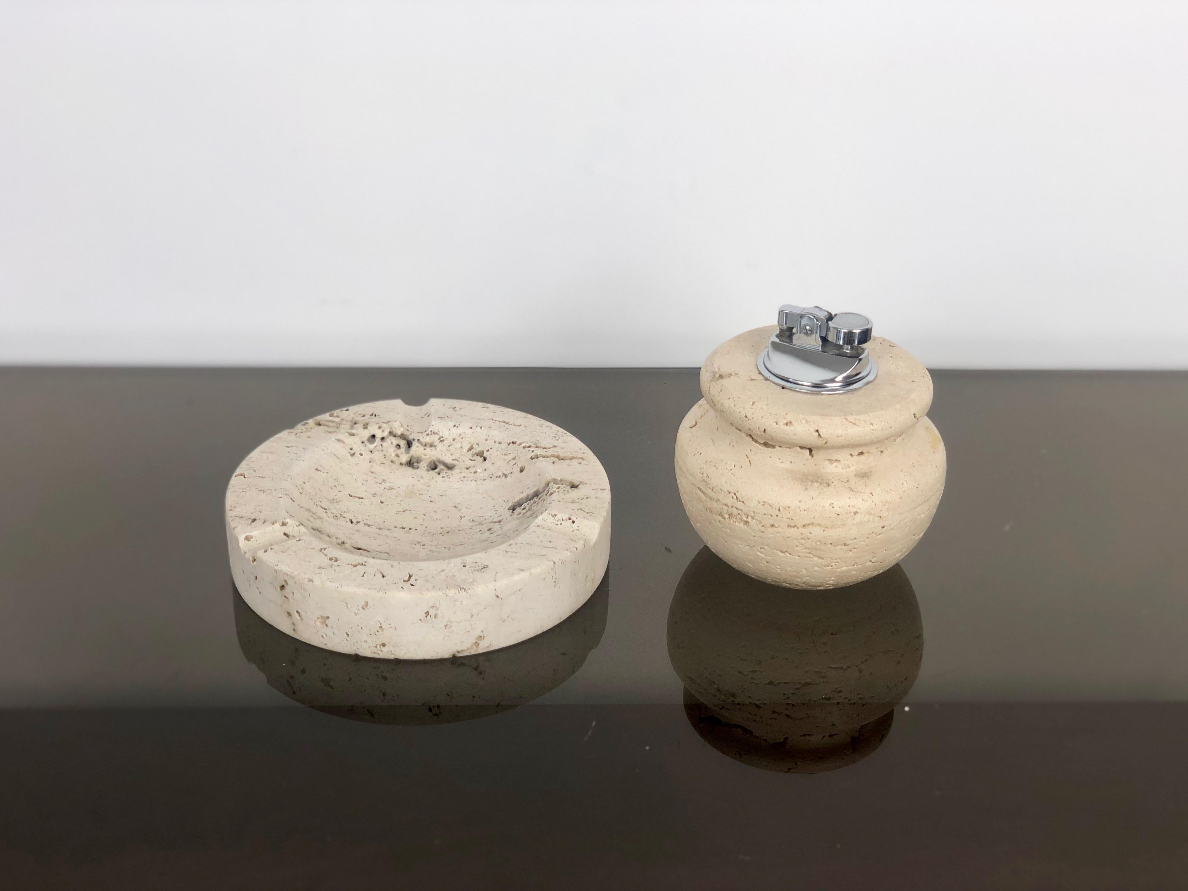 Table set of ashtray and lighter in travertine marble, attributed to the Italian designers Fratelli Manelli - Italy, 1970s. 

Dimensions: 
Ashtray: 3 x 15 cm. 
Lighter: 10 x 10 cm.