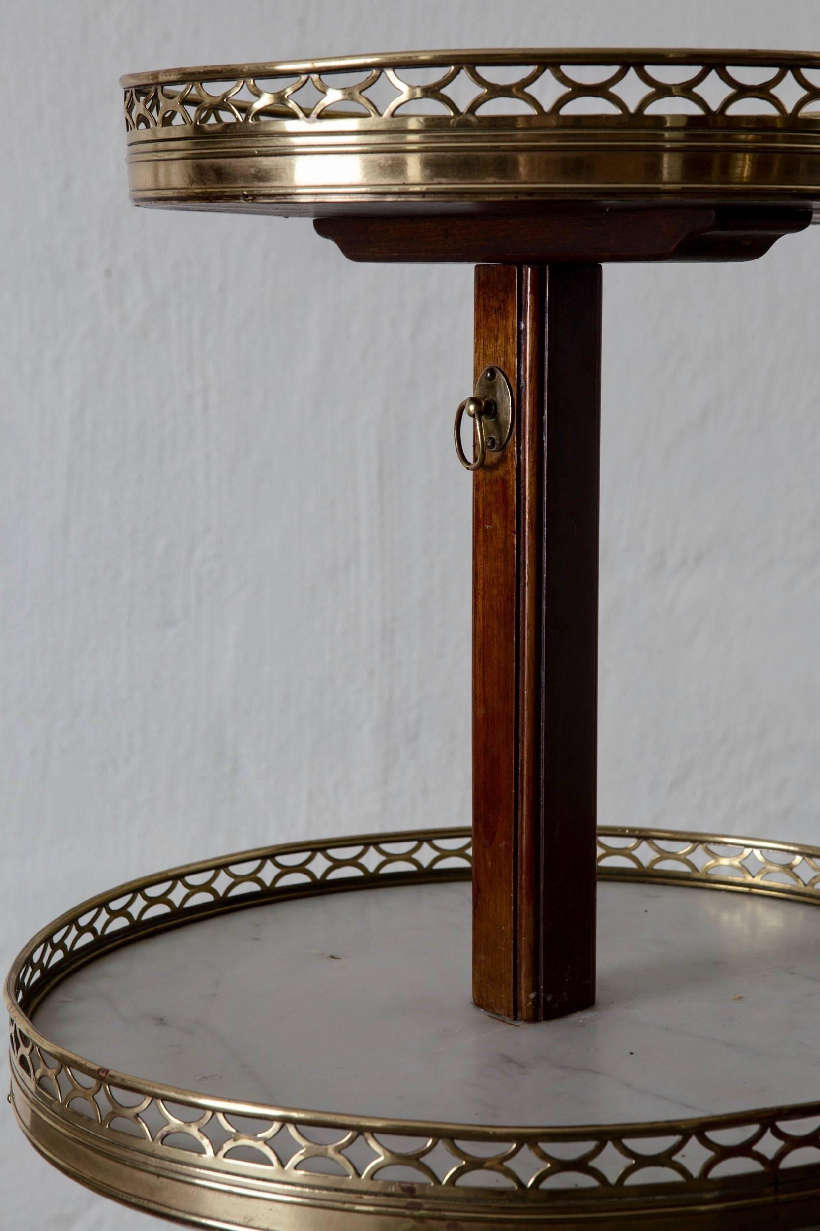 Table tier English mahogany brass marble, 19th century England. A side table made during the end of 18th century / beginning of 19th century in England. Tiers from white marble trimmed with a brass edge. Tripod with the shapes of human legs and feet.