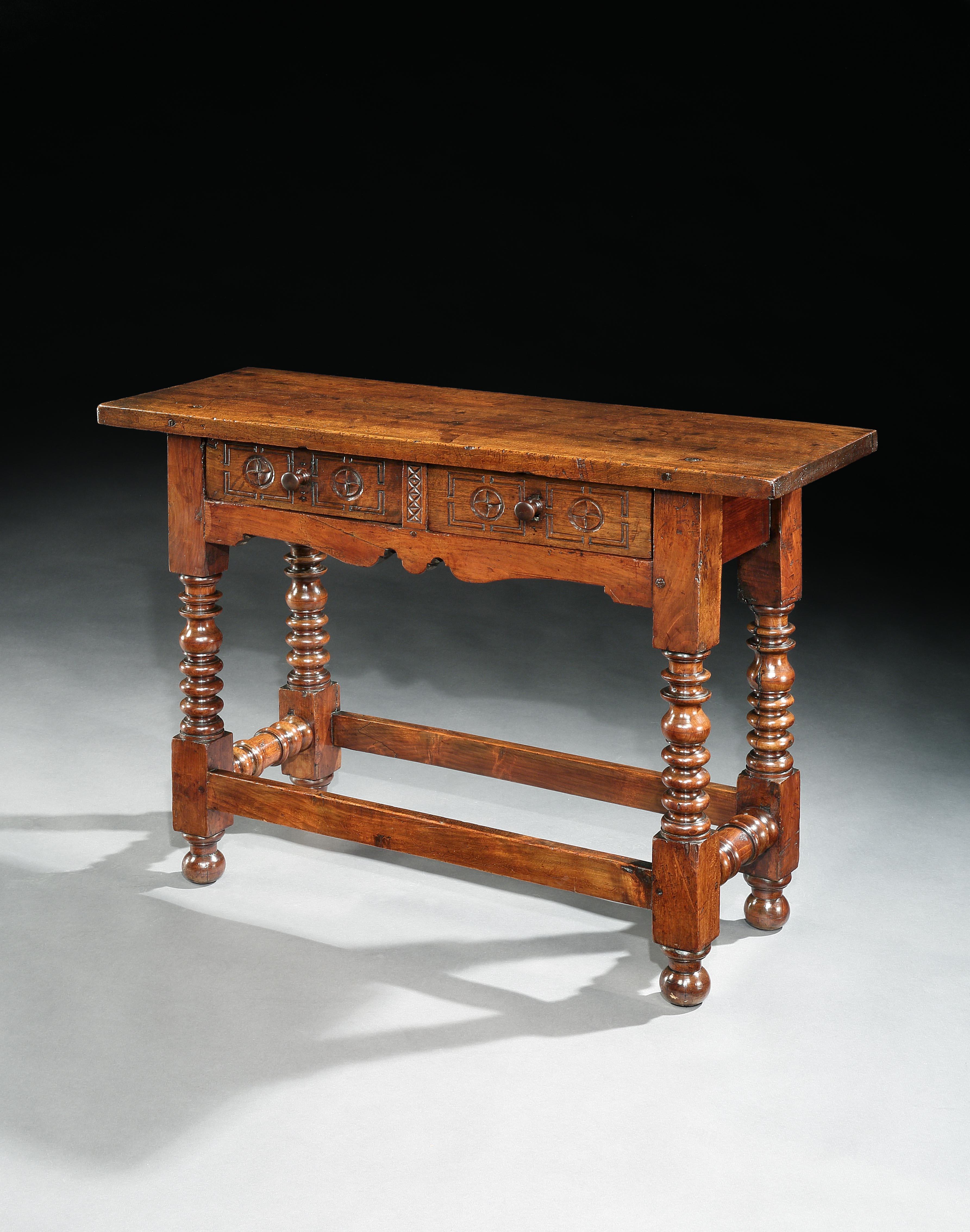 Dieser charaktervolle Tisch hat die seltene schmale Tiefe von 39 cm. Es ist charakteristisch für spanische Barockmöbel mit einer dicken, einteiligen Platte, einfachen, kühn geschnitzten Ornamenten und kühnen Drechselarbeiten. Es hat eine